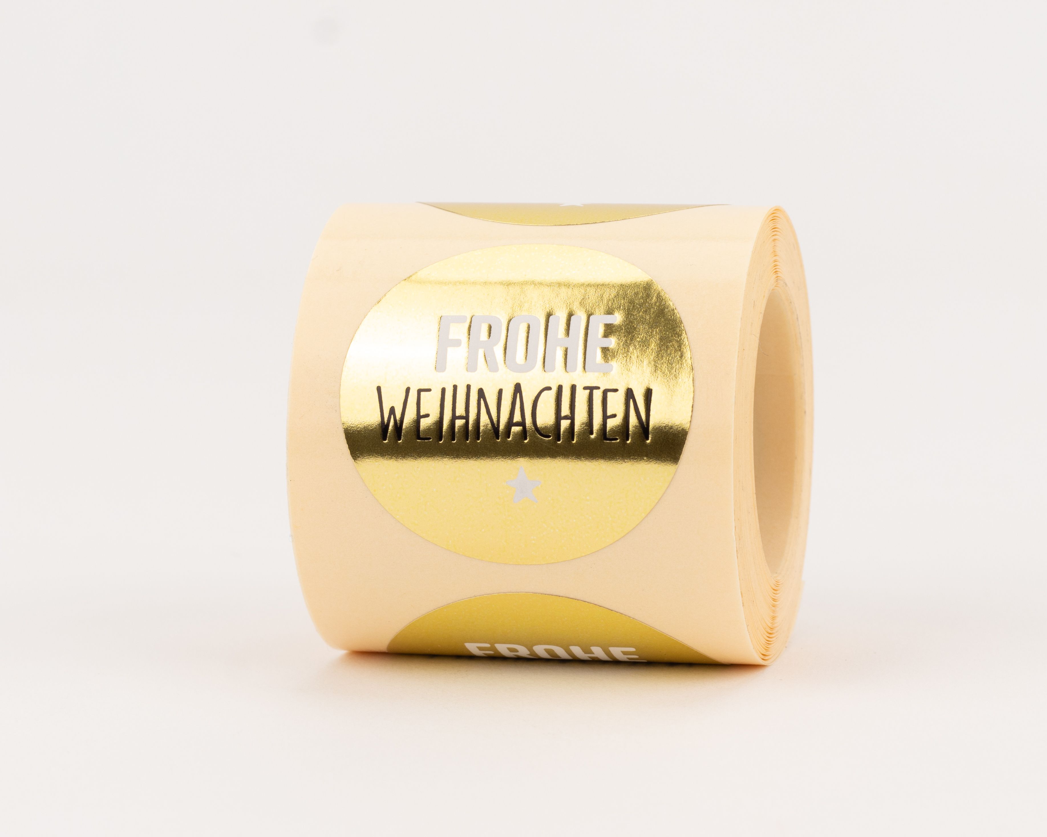Aufkleber mit glänzender goldener Farbe zeigen den Schriftzug Frohe Weihnachten und einen kleinen Stern für festliche Akzente