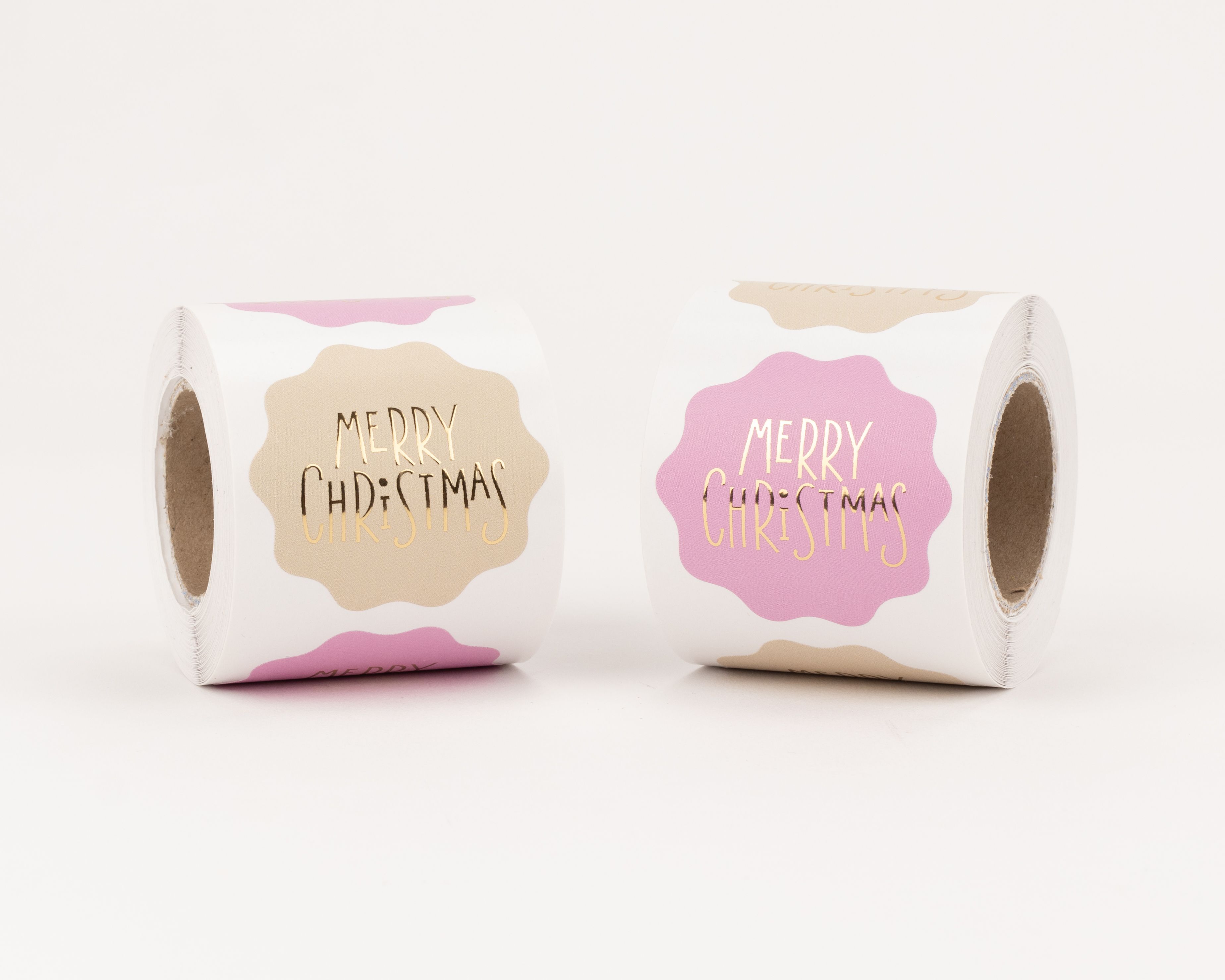 Aufkleber mit zwei verschiedenen Designs zeigen goldfarbenen Merry Christmas Schriftzug auf beigen und pinken, wolkenförmigen Formen