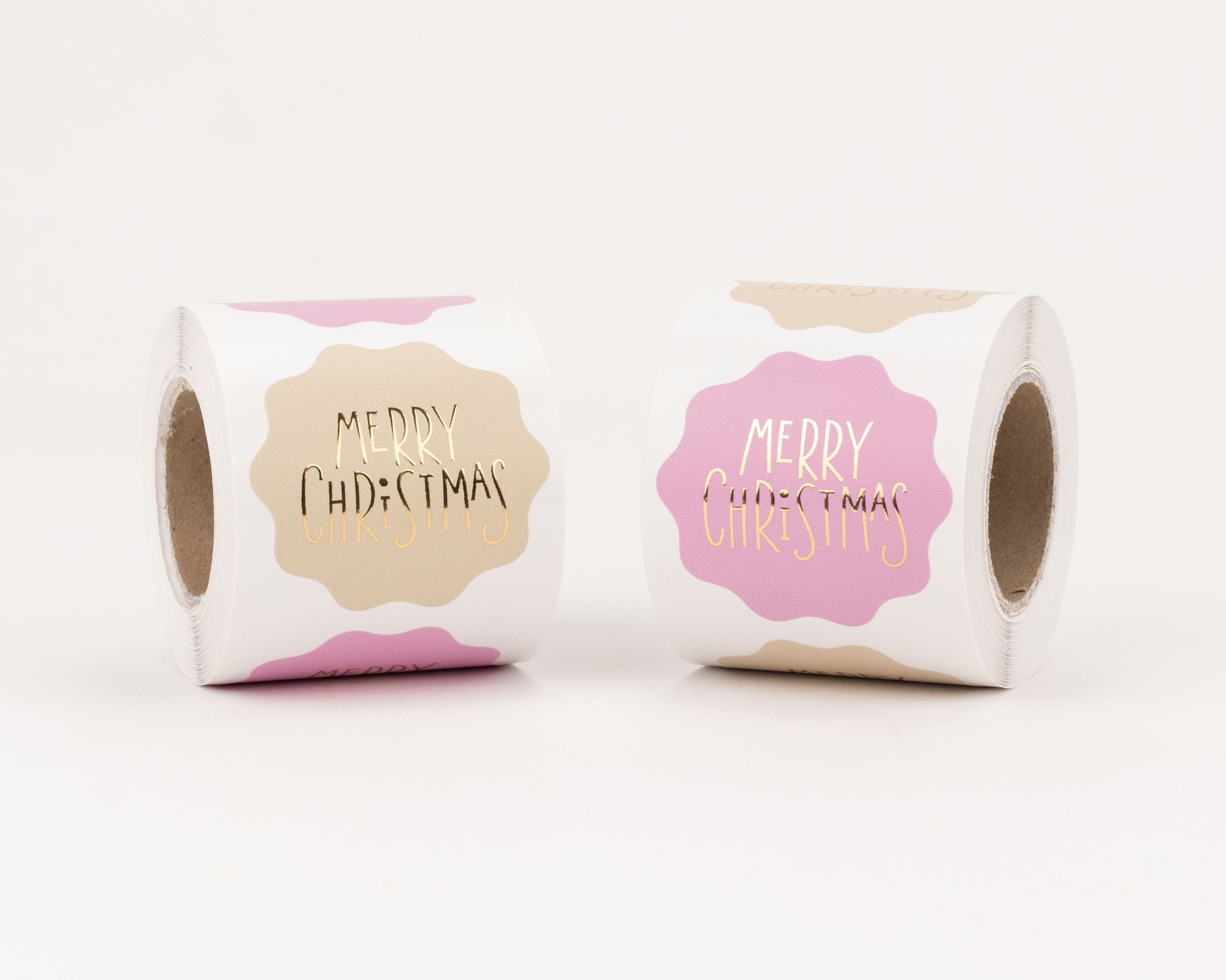 Aufkleber mit zwei verschiedenen Designs zeigen goldfarbenen Merry Christmas Schriftzug auf beigen und pinken, wolkenförmigen Formen
