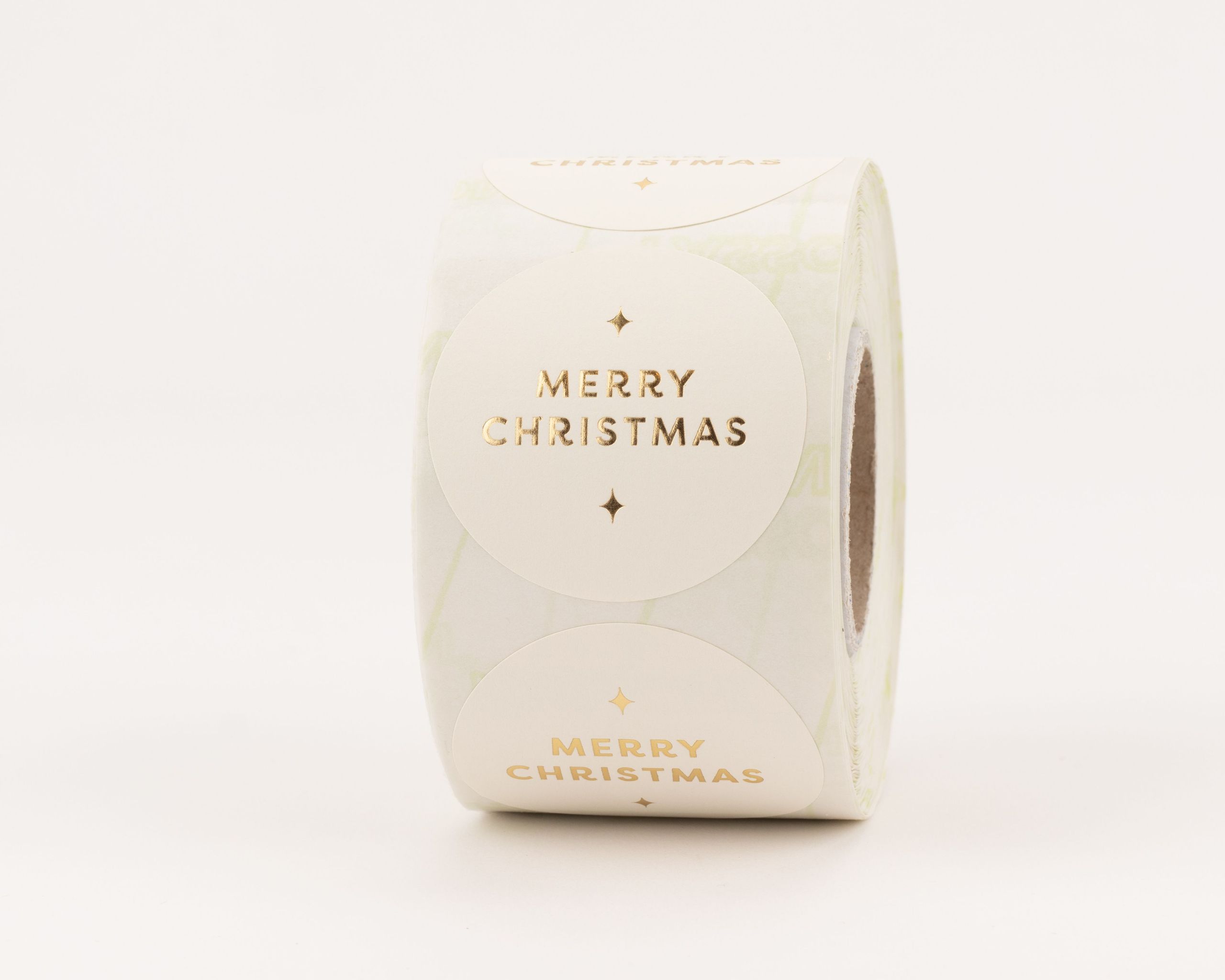 Runde Aufkleber mit cremfarbenem Hintergrund und goldenem "Merry Christmas" Schriftzug sowie funkelnden Sternen
