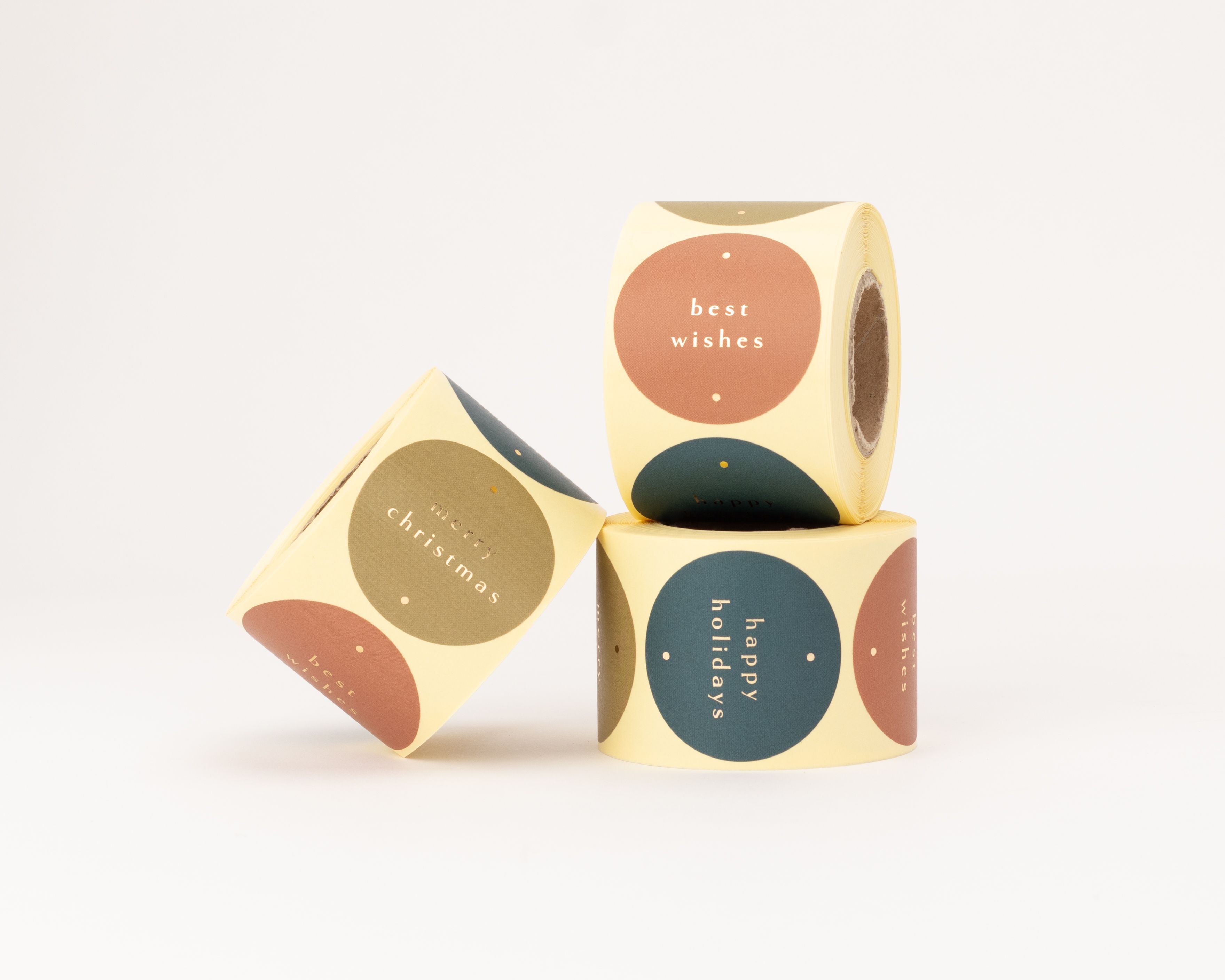 Aufkleber mit drei runden Designs in Goldoptik. Sie zeigen goldene Schriftzüge auf bunten Kreisen mit hellgelbem Rand