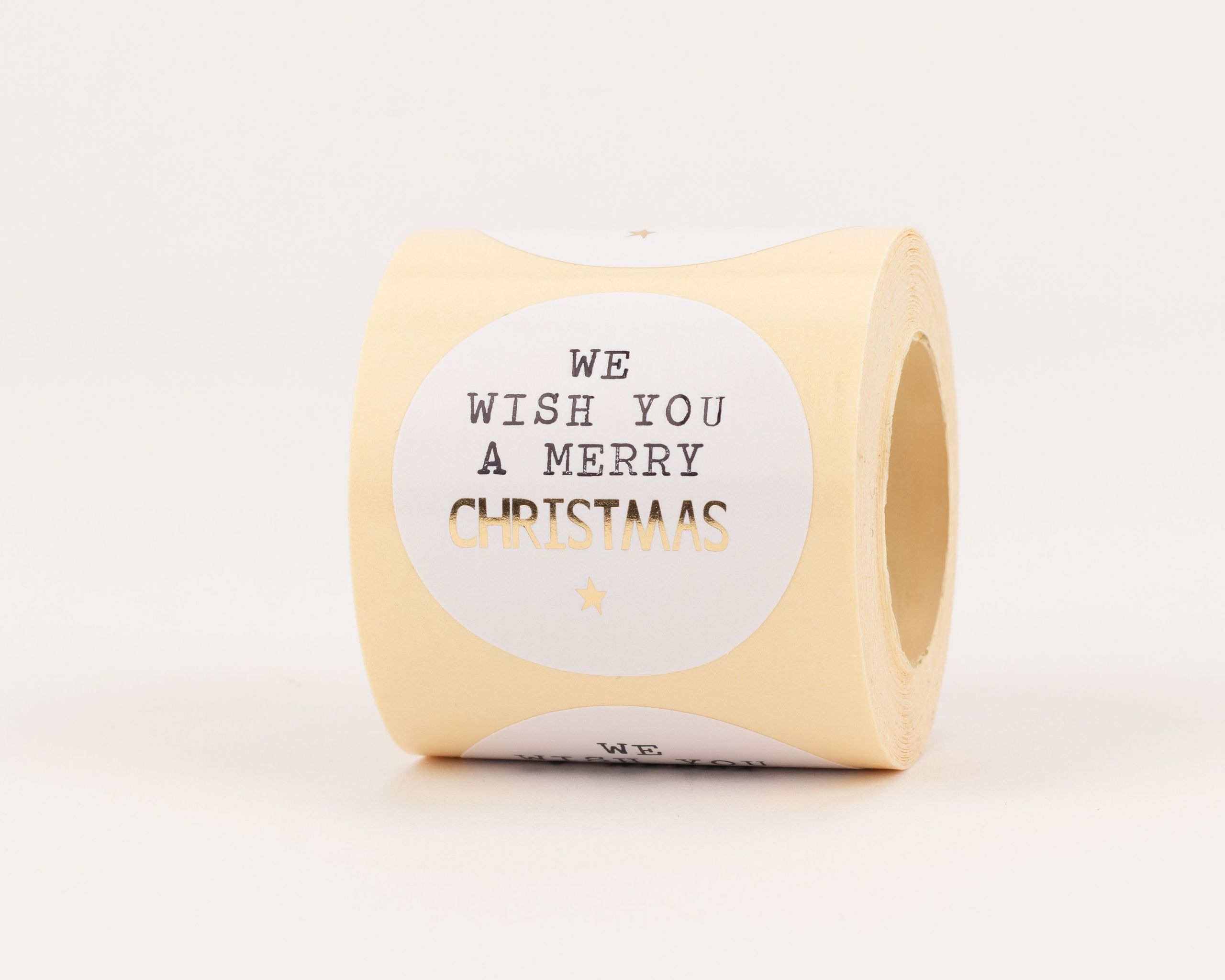 Aufkleber mit weißem Kreis, darauf der Spruch "We Wish You a Merry Christmas" und ein kleiner Stern in glänzendem Gold-Effekt