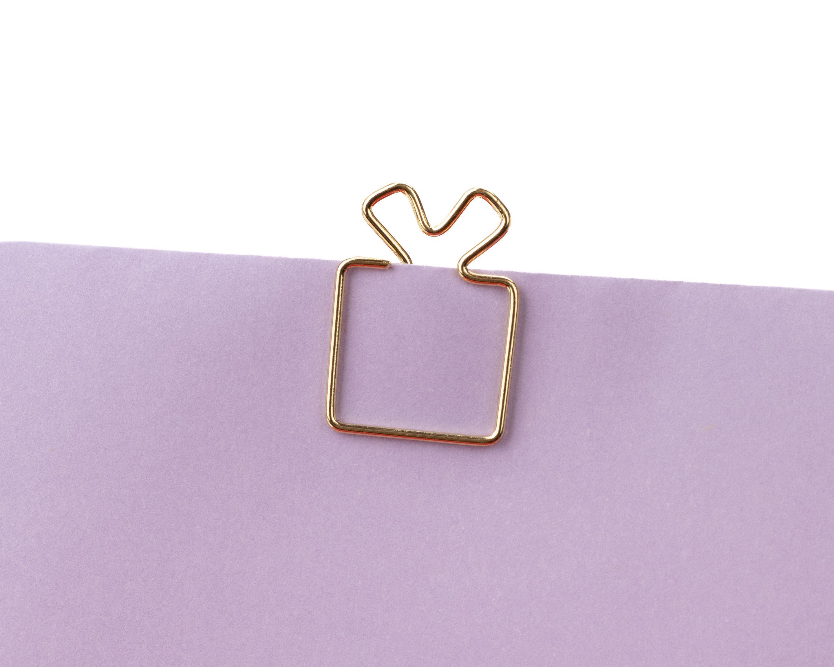 Goldfarbene Clips aus Metall, die wie ein kleines Geschenk mit einer Schleife oben geformt sind