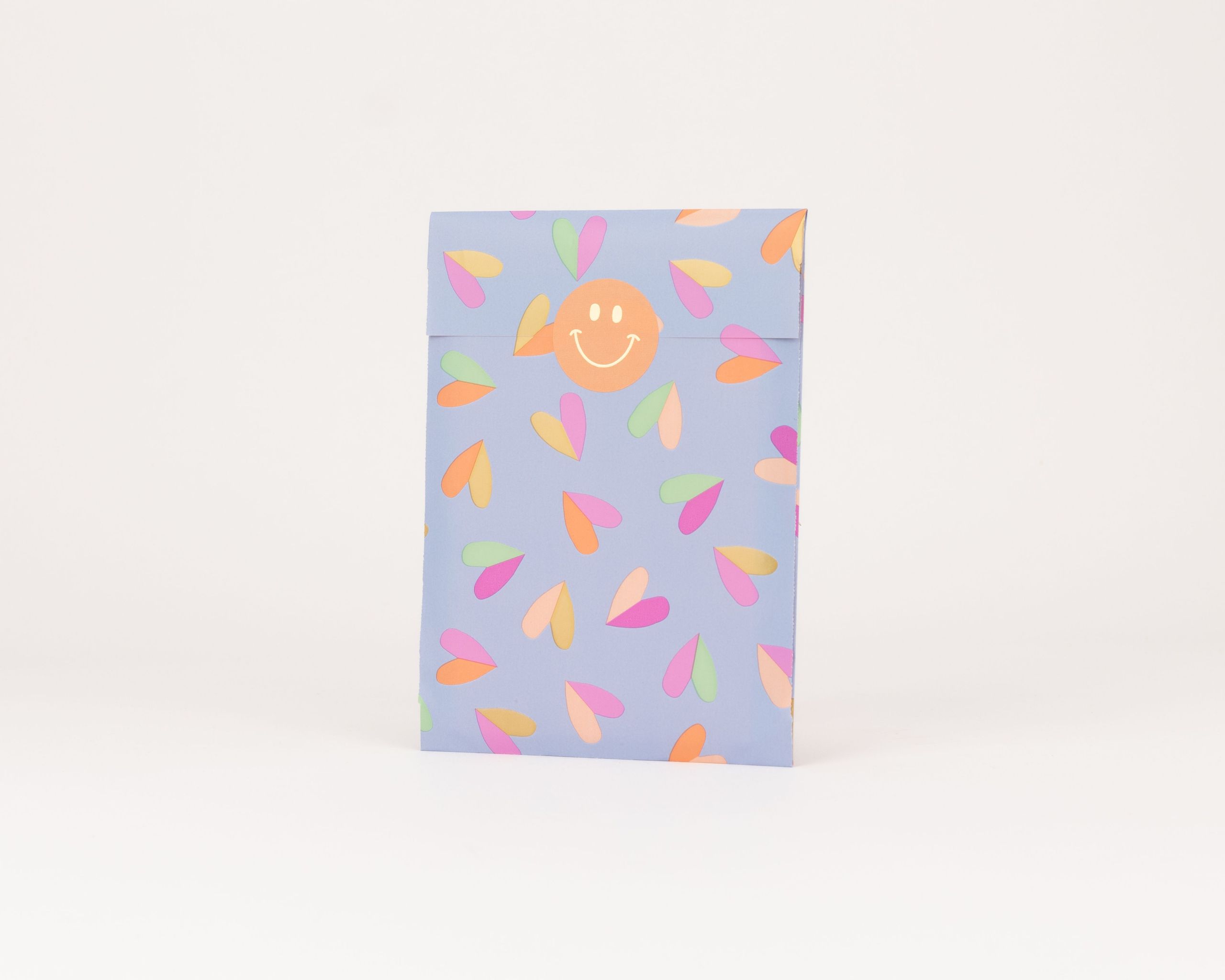 Flachbeutel mit blauem Hintergrund und Herzen in Pink Grün Orange Gold Goldeffekt und einem orangen Smiley die Innenseite ist blau