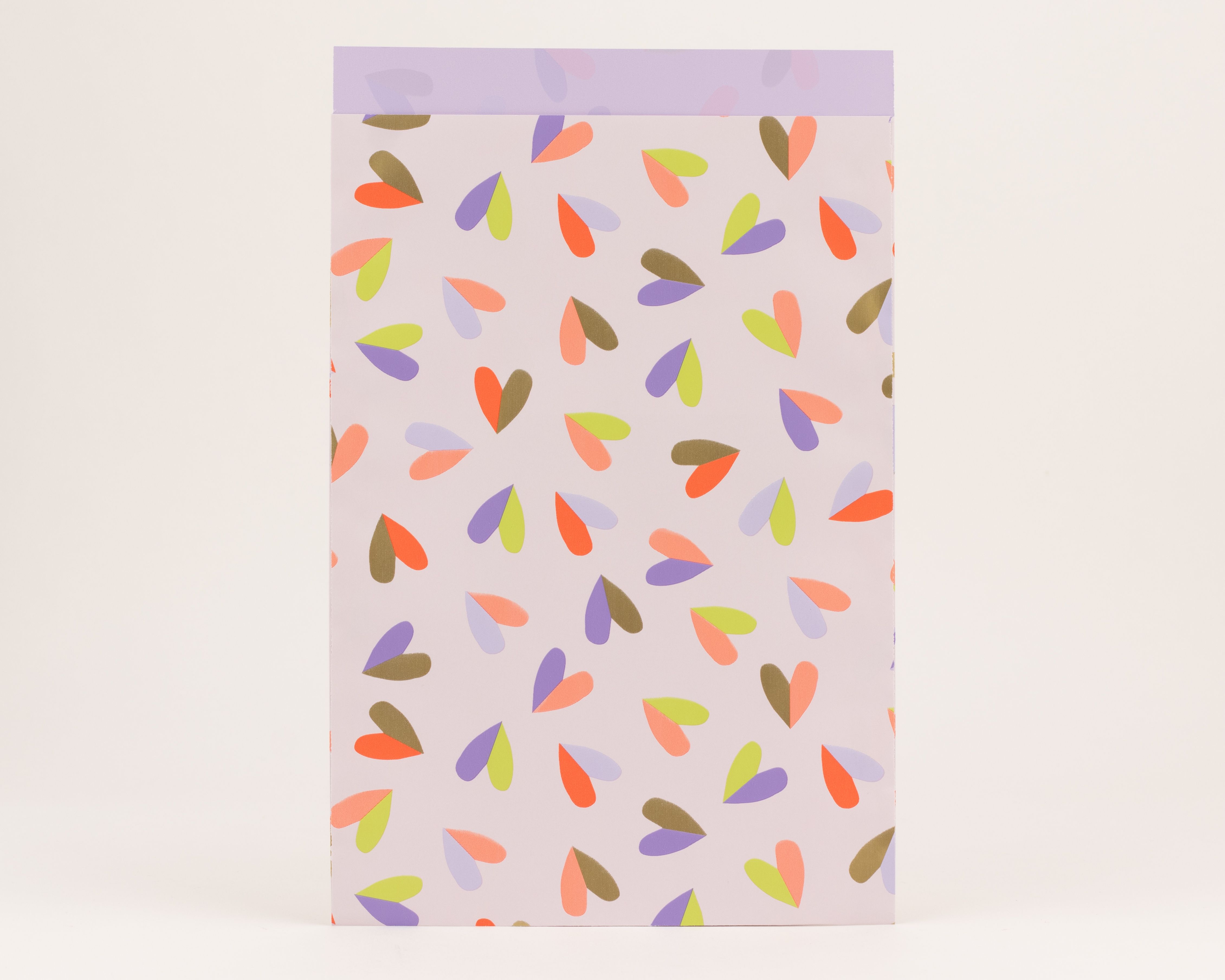 Papiertüten mit Herzmuster in Orange, Violett und Limettengrün auf fliederfarbenem Grund. Die Innenseite ist einfarbig Violett