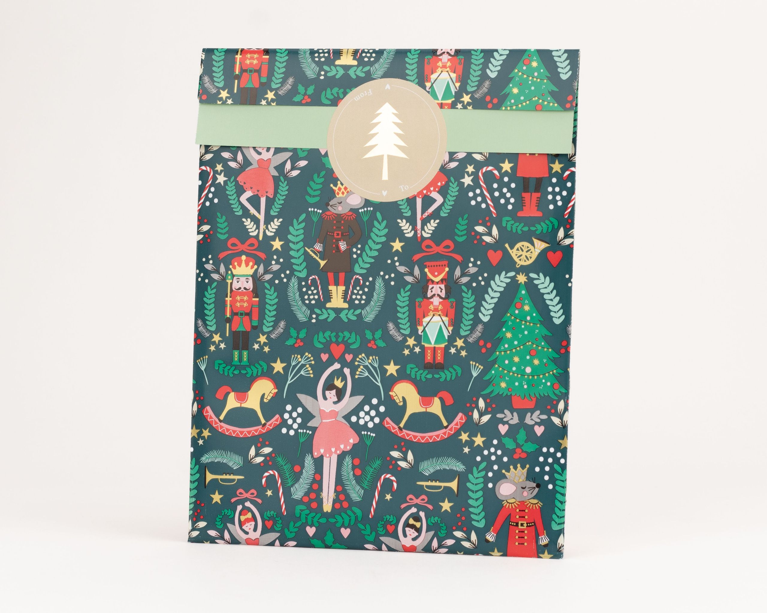 Flachbeutel in Dunkelgrün mit Nussknacker-, Ballerina- und Weihnachtsbaum-Motiven. Die Innenseite ist hellgrün und bildet einen Kontrast