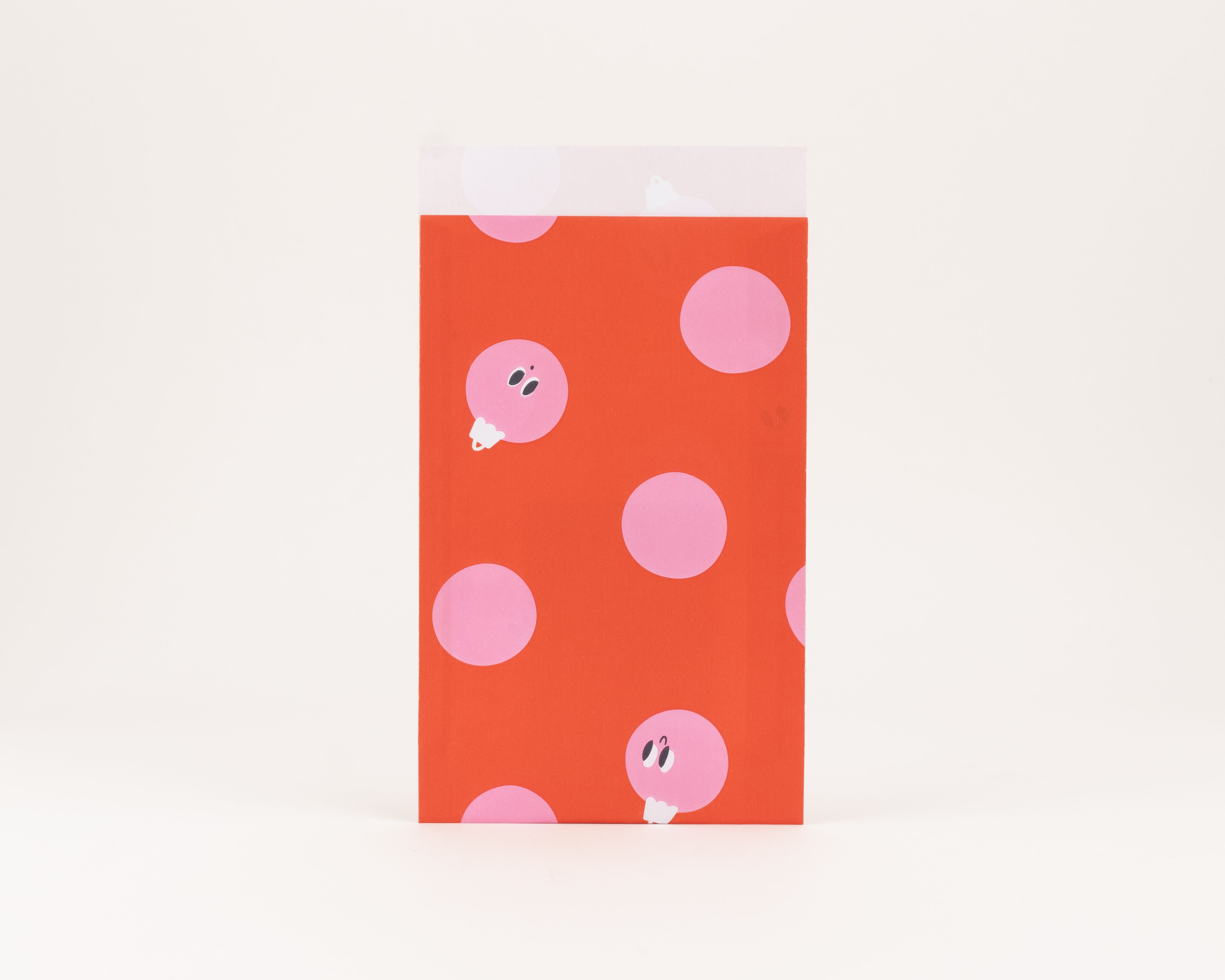 Flachbeutel in Rot mit pinken Punkten und verspielten Peek-a-Boo Baubles Motiven, die Innenseite ist Weiß