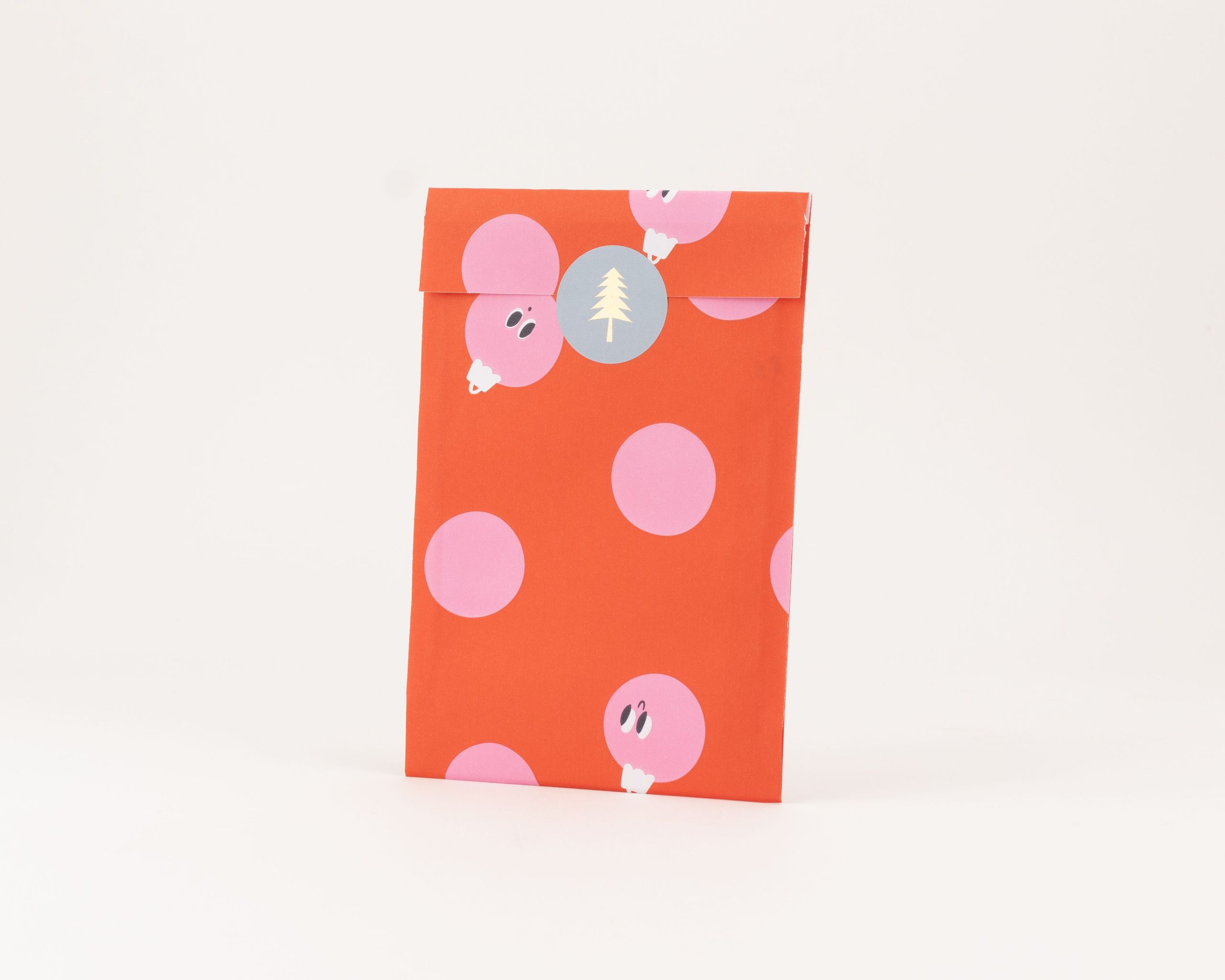 Flachbeutel in Rot und Pink mit einem Peek-a-Boo Baubles Muster auf der Außenseite und identischer Gestaltung auf der Innenseite