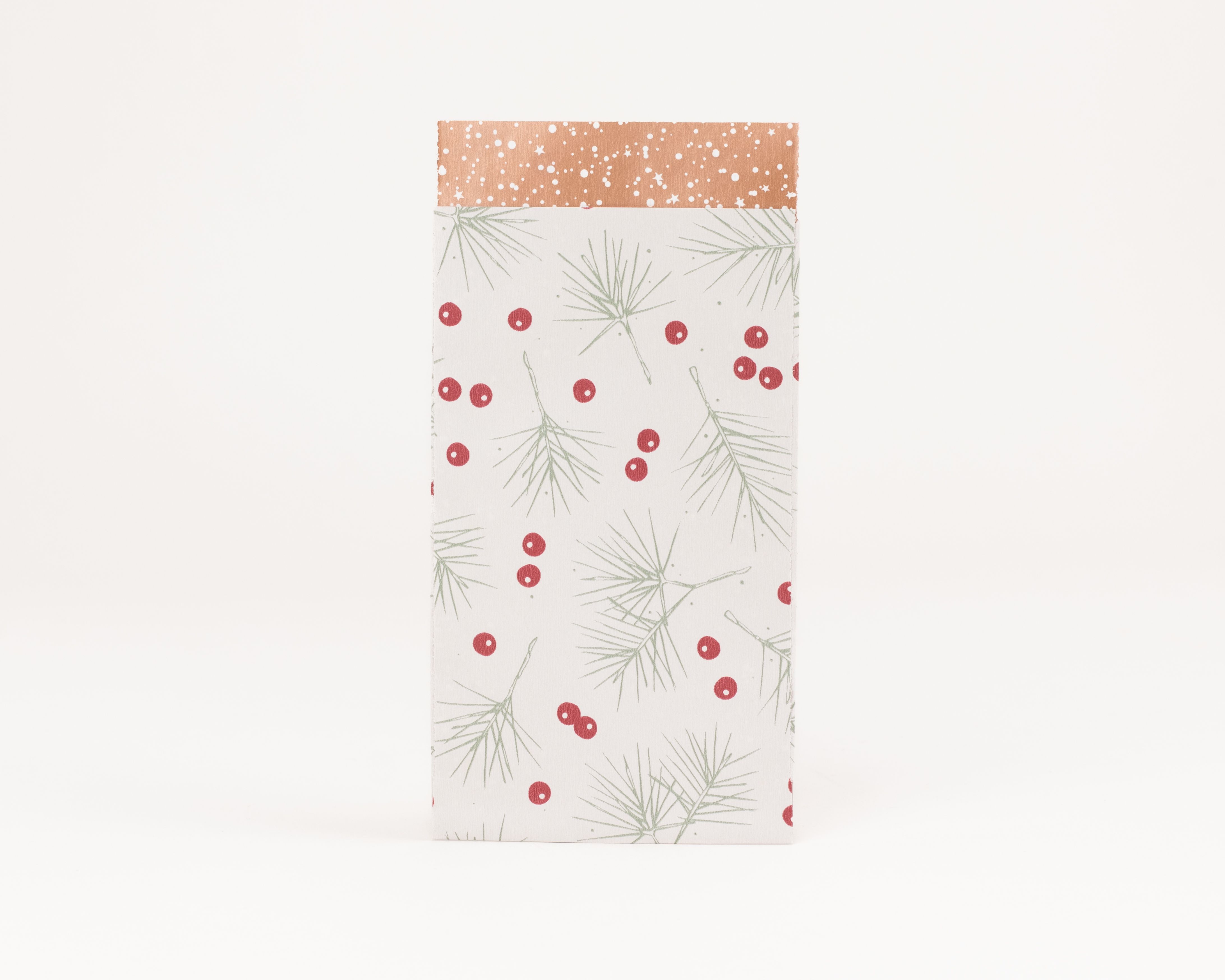 Flachbeutel mit Design aus grünen Tannenzweigen und roten Beeren auf hellem Grund, dazu kupferfarbene Innenseite mit weißen Sternen