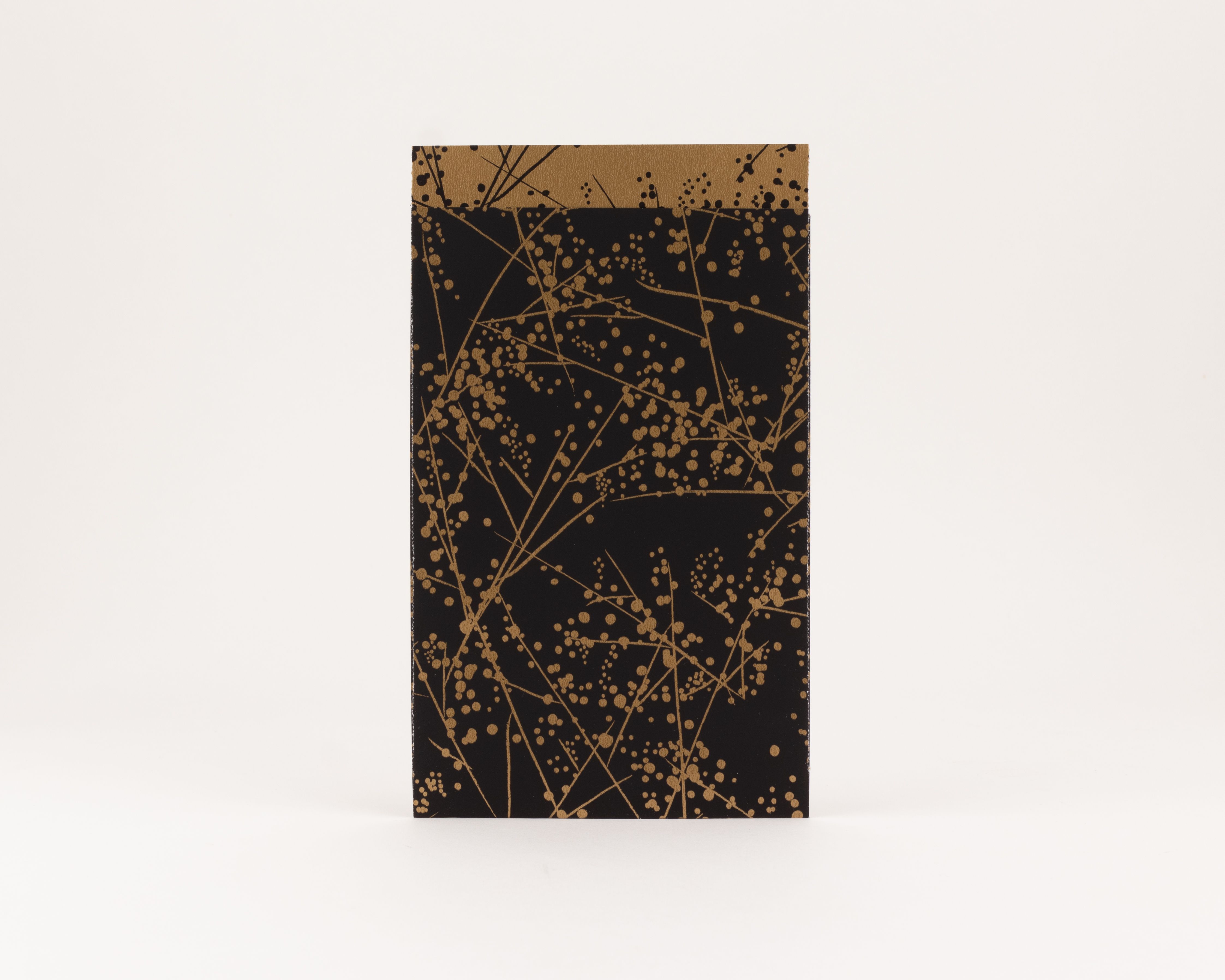 Flachbeutel mit einem Winterfrost-Muster in Schwarz und Gold auf der Außenseite und einer durchgehend goldfarbenen Innenseite