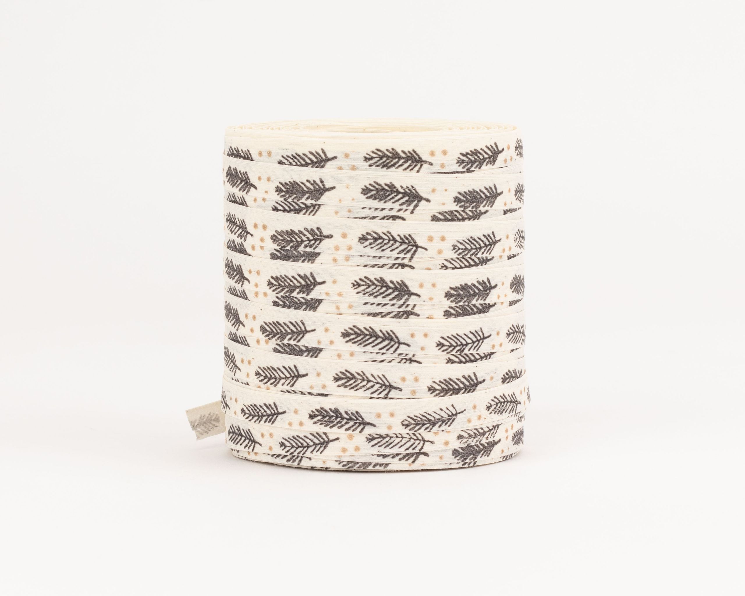 Geschenkband aus Stoff in Creme mit durchgehendem Muster aus grauen Tannenästen und kleinen goldenen Punkten