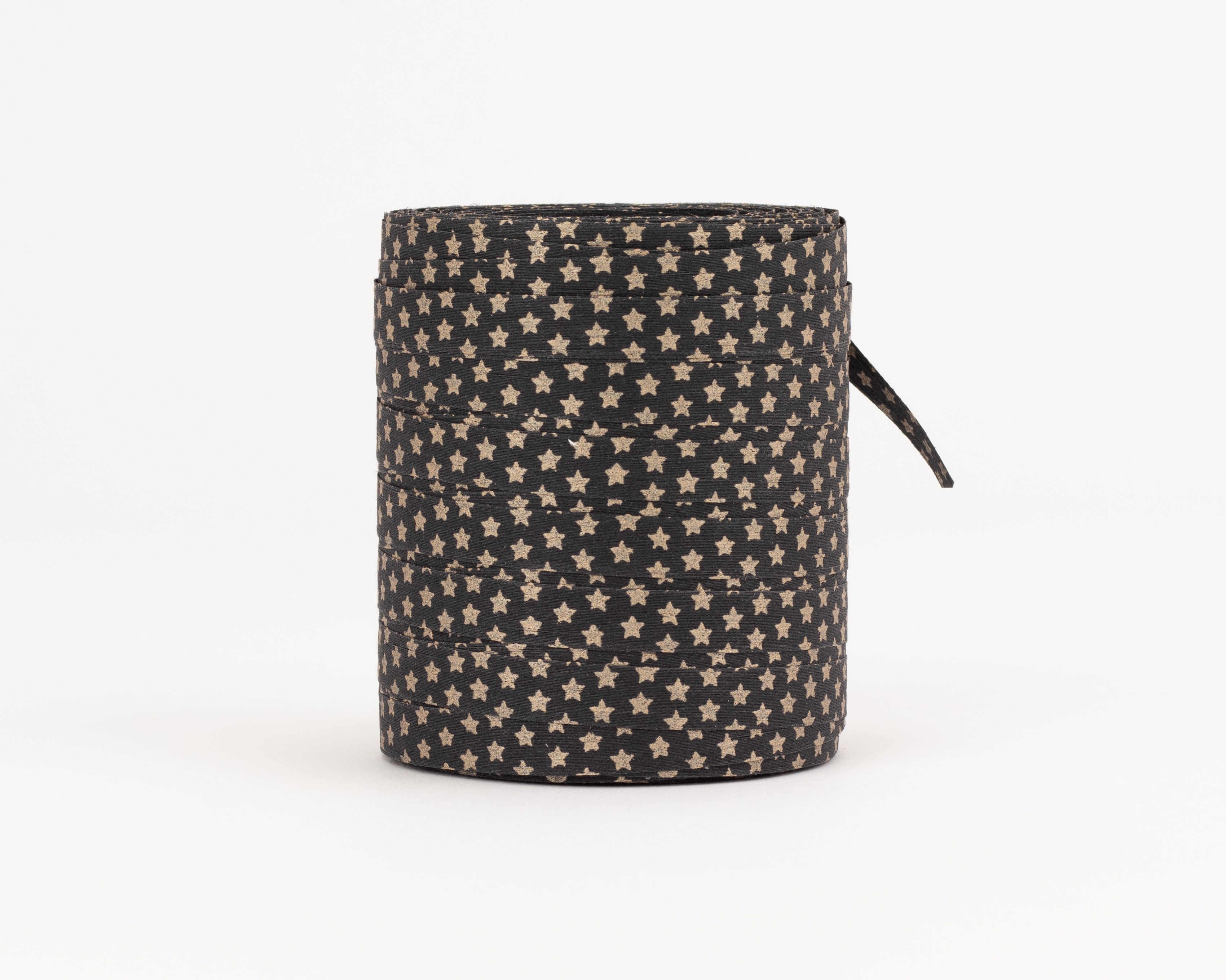 Geschenkband auf einer Rolle in Schwarz mit einem Muster aus goldenen Sternen