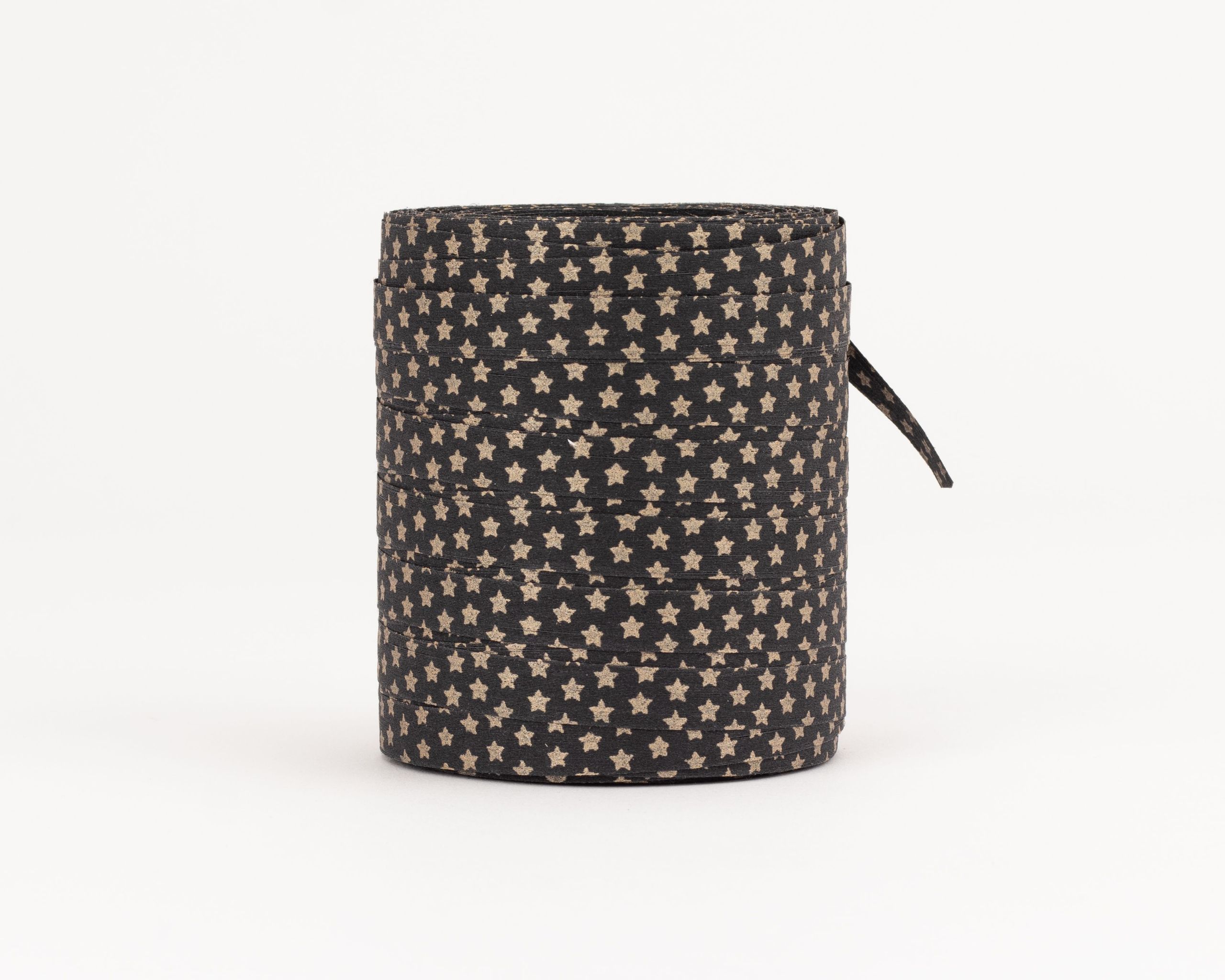 Geschenkband auf einer Rolle in Schwarz mit einem Muster aus goldenen Sternen