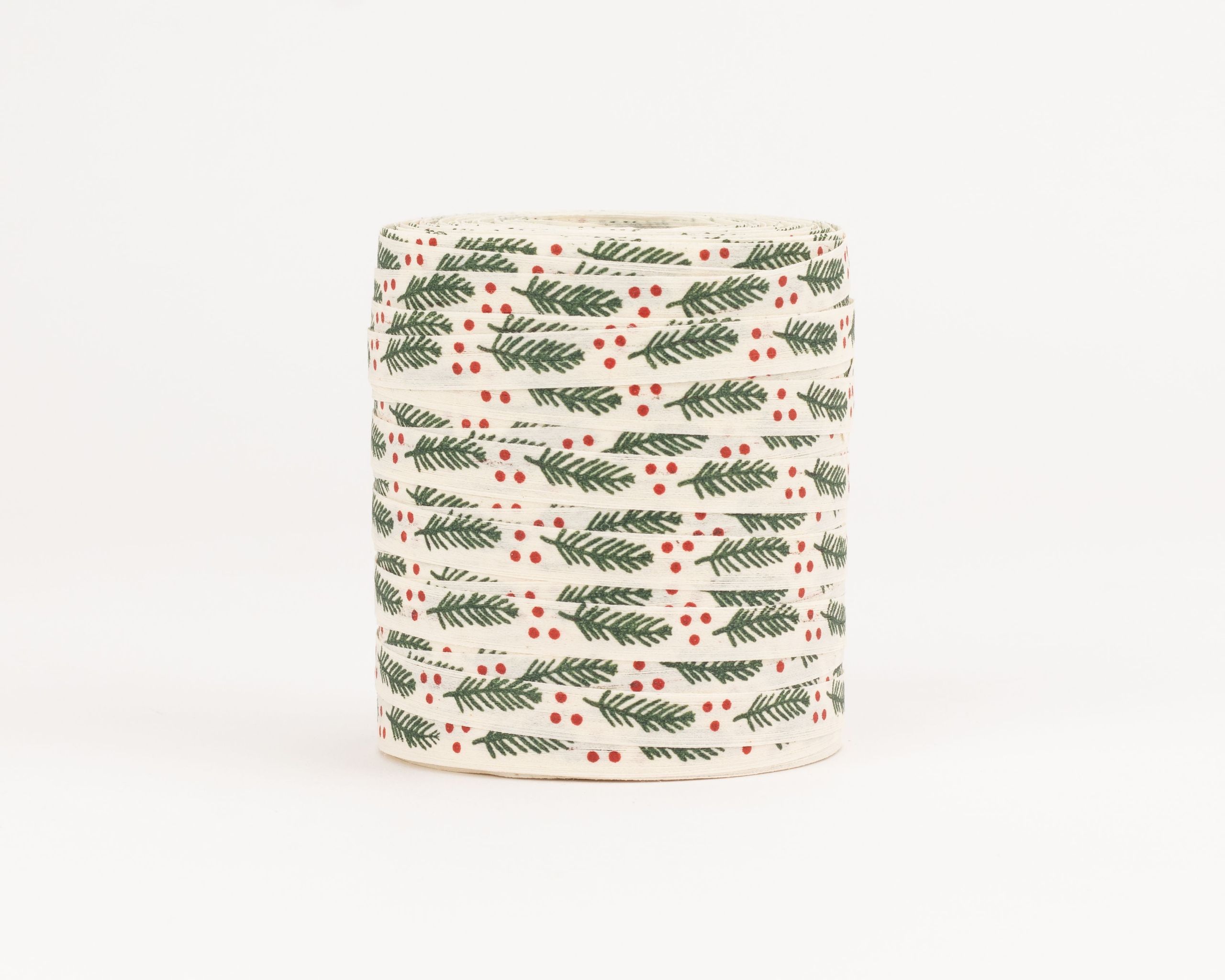Geschenkband aus Stoff mit einem Muster aus dunkelgrünen Tannenzweigen und kleinen roten Beeren auf cremefarbenem Grund