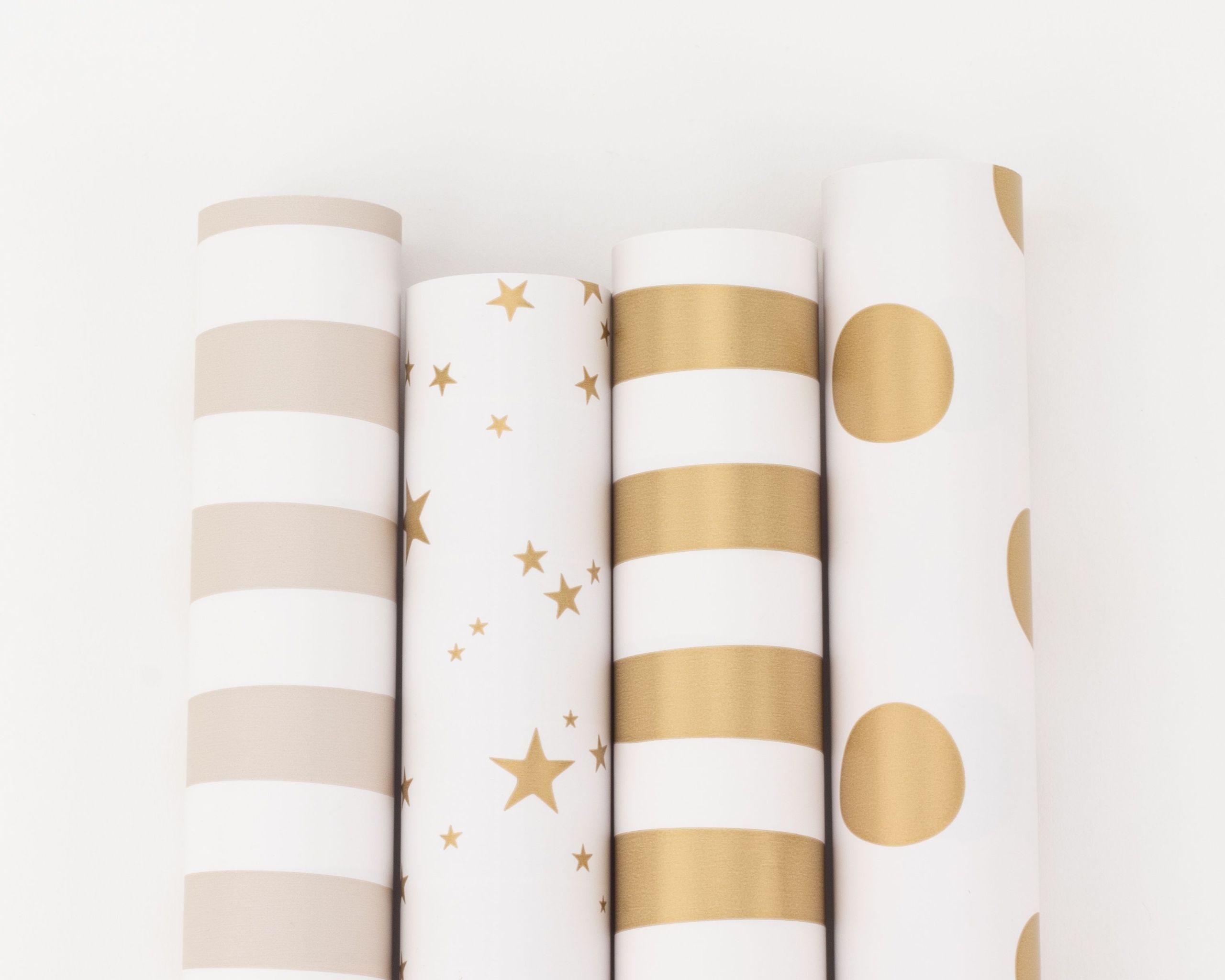 Geschenkpapier-Set mit vier Rollen in den Farben Gold, Weiß und Beige, die verschiedene Muster wie Streifen, Sterne und Punkte zeigen