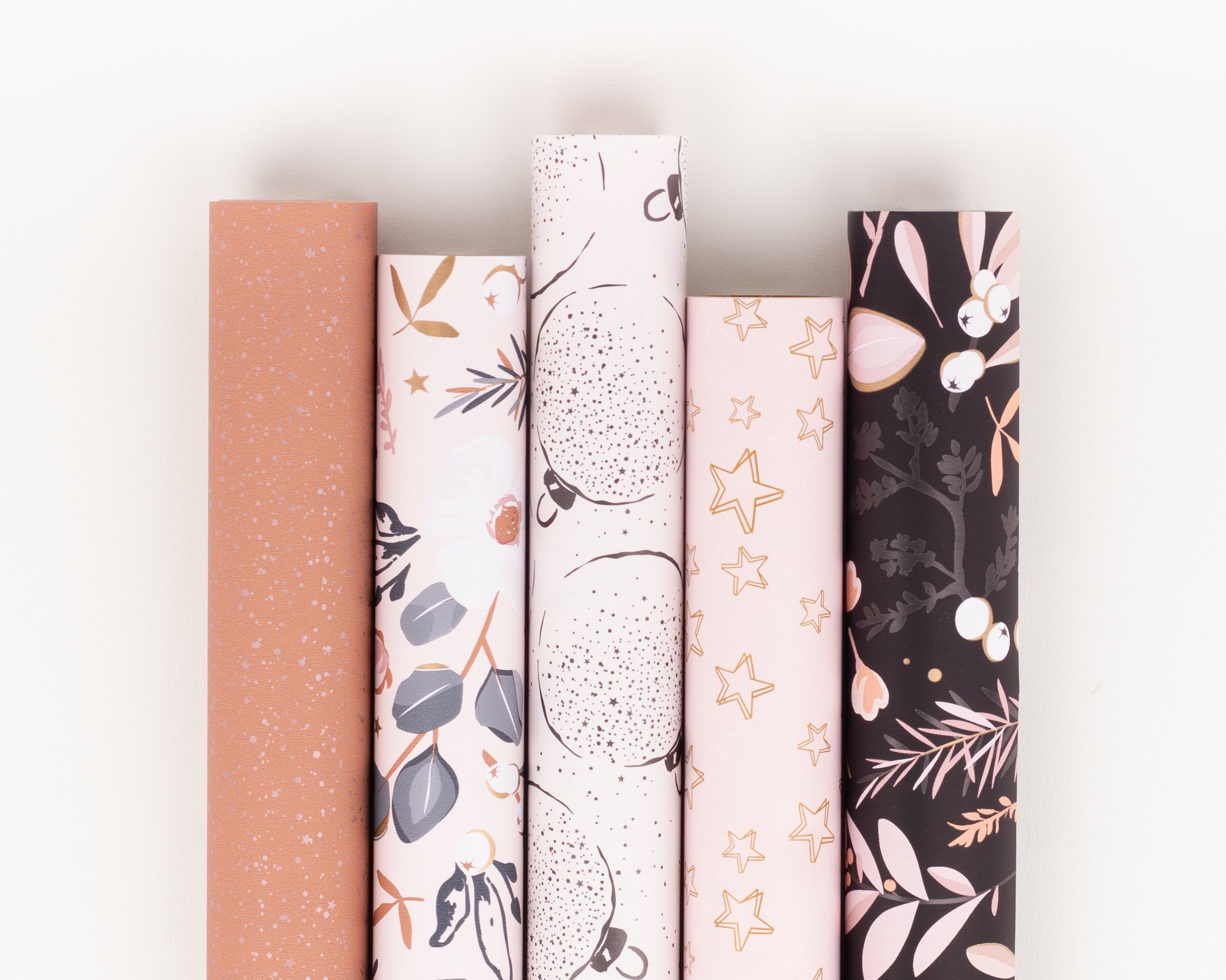 Geschenkpapier-Set mit fuenf Rollen in Rosa, Weiss, Grau und Dunkelgrau, mit festlichen Sternen, Punkten und botanischen Mustern