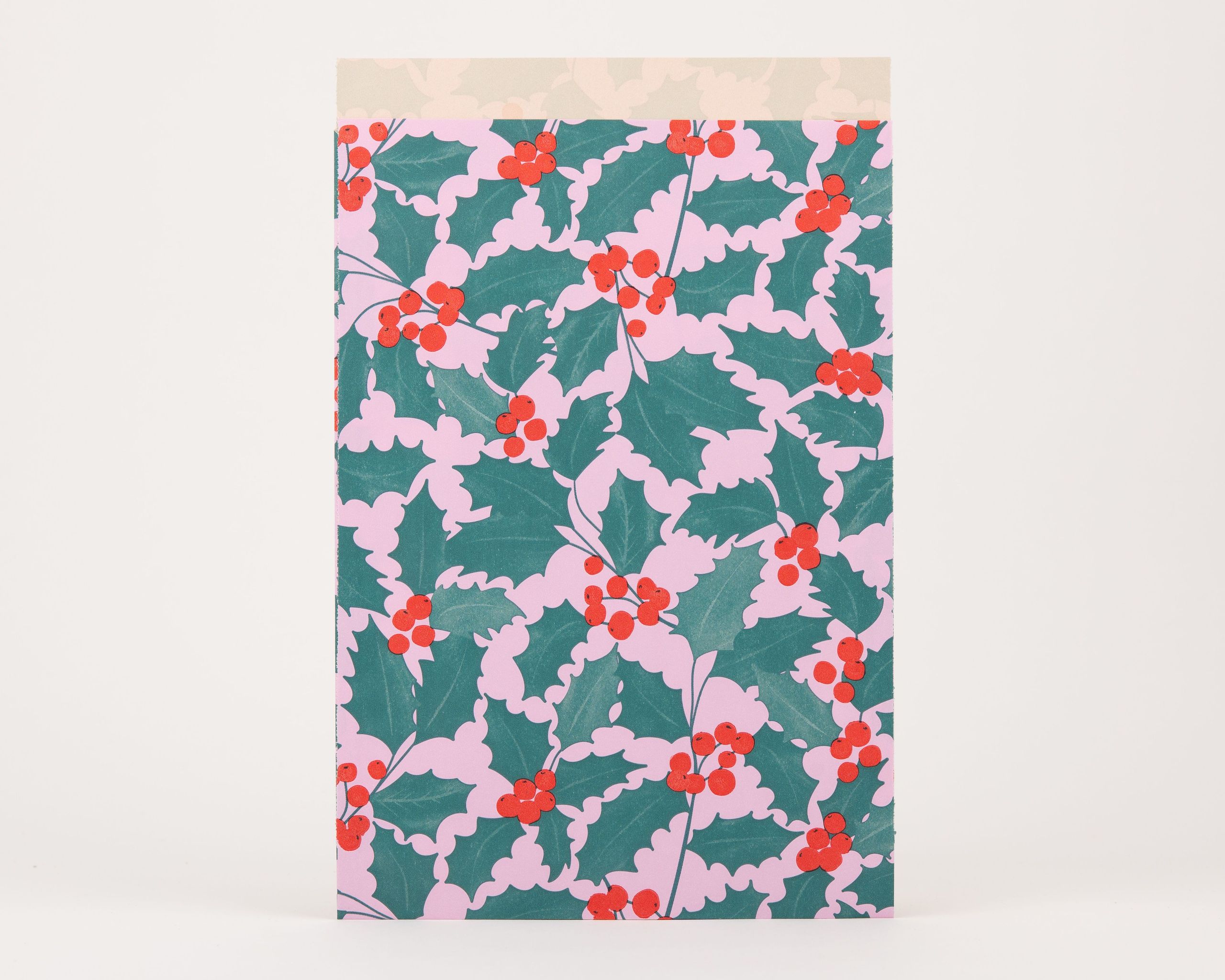 Papiertüten Flachbeutel mit Ilex-Muster in Rosa, Grün und Rot auf der Außenseite, die Innenseite ist Beige mit dezentem Blattmuster