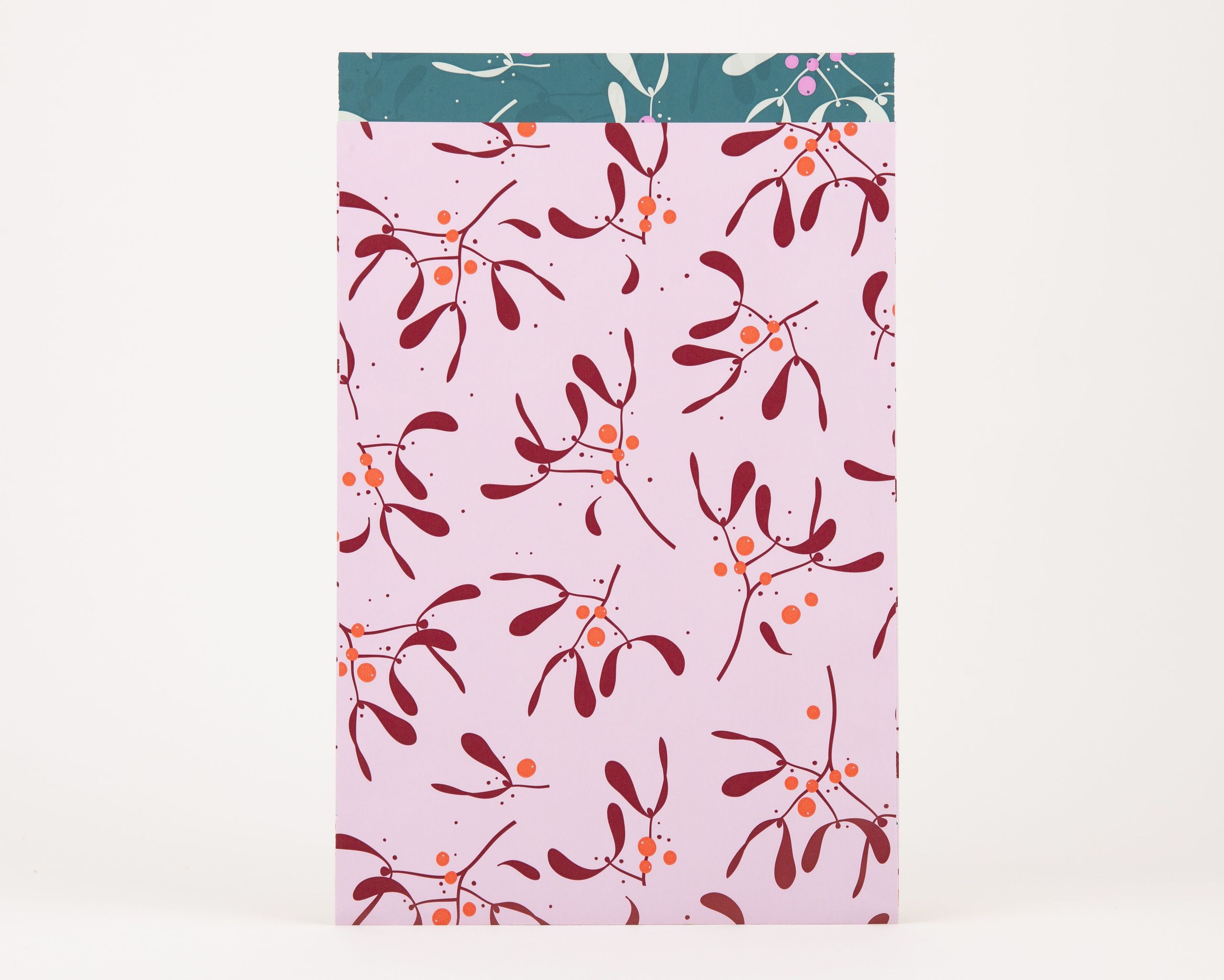 Papiertüten Flachbeutel mit Mistelzweig-Muster in Hellrosa, Weinrot und Orange. Die Innenseite zeigt ein Petrol-Design mit weißen und magenta Zweigen