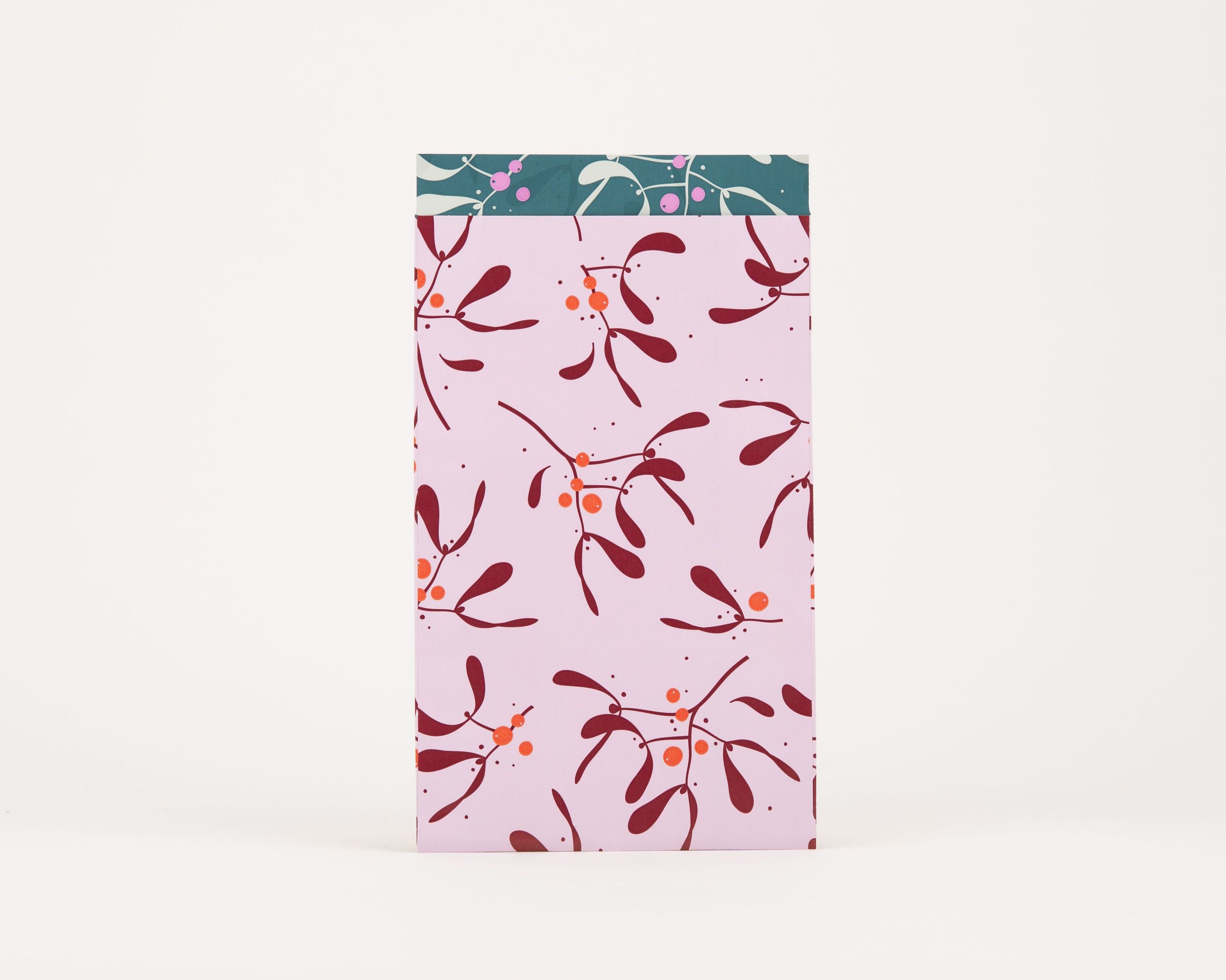 Papiertüten Flachbeutel, außen hellrosa mit weinroten Mistelzweigen und orangen Beeren. Innen petrolfarben mit weißem Muster und Magenta-Punkten