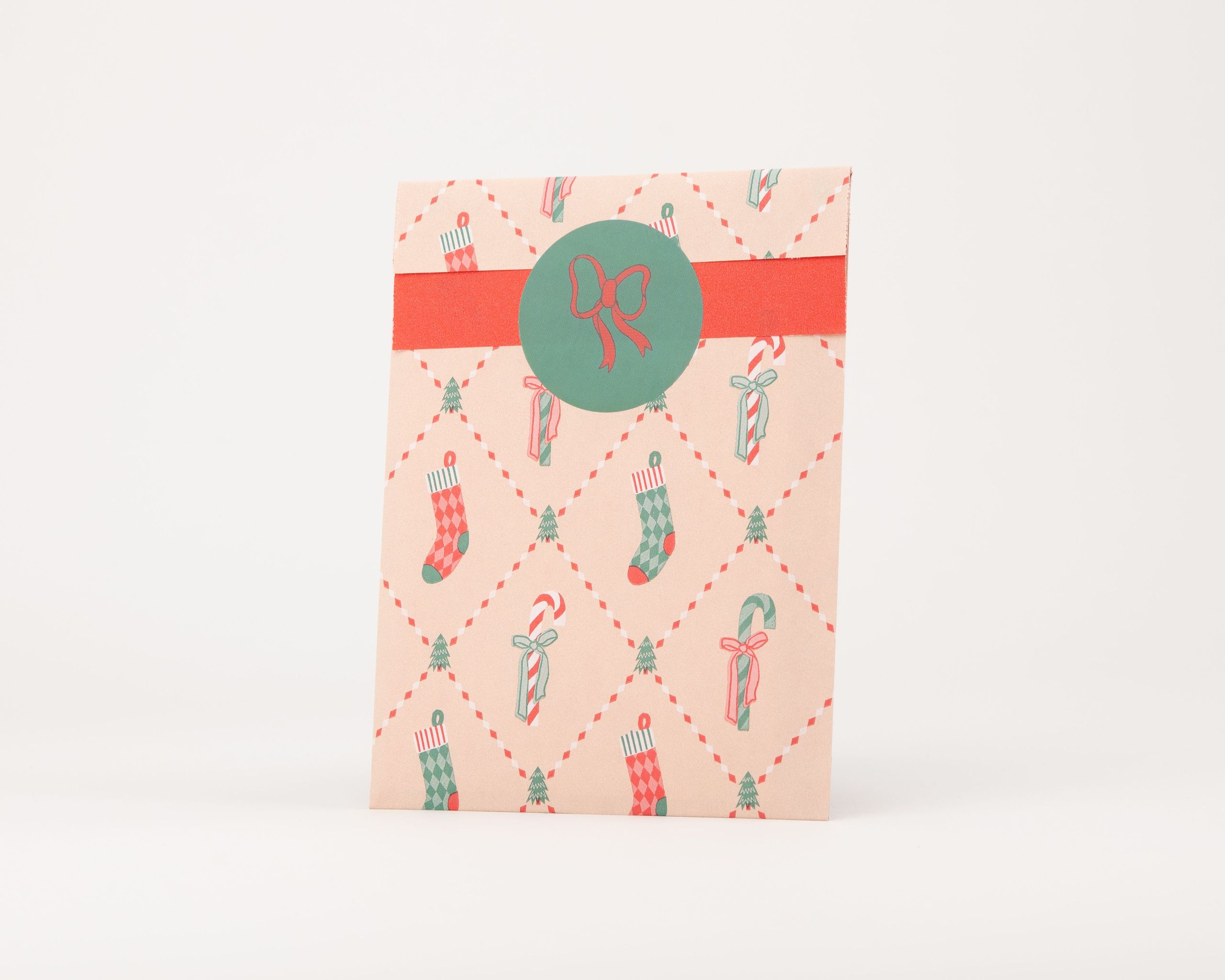 Papiertüten Flachbeutel im Retro Weihnachtsdesign in Beige mit Motiven in Rot und Grün. Die Innenseite ist ebenfalls Beige mit Muster.