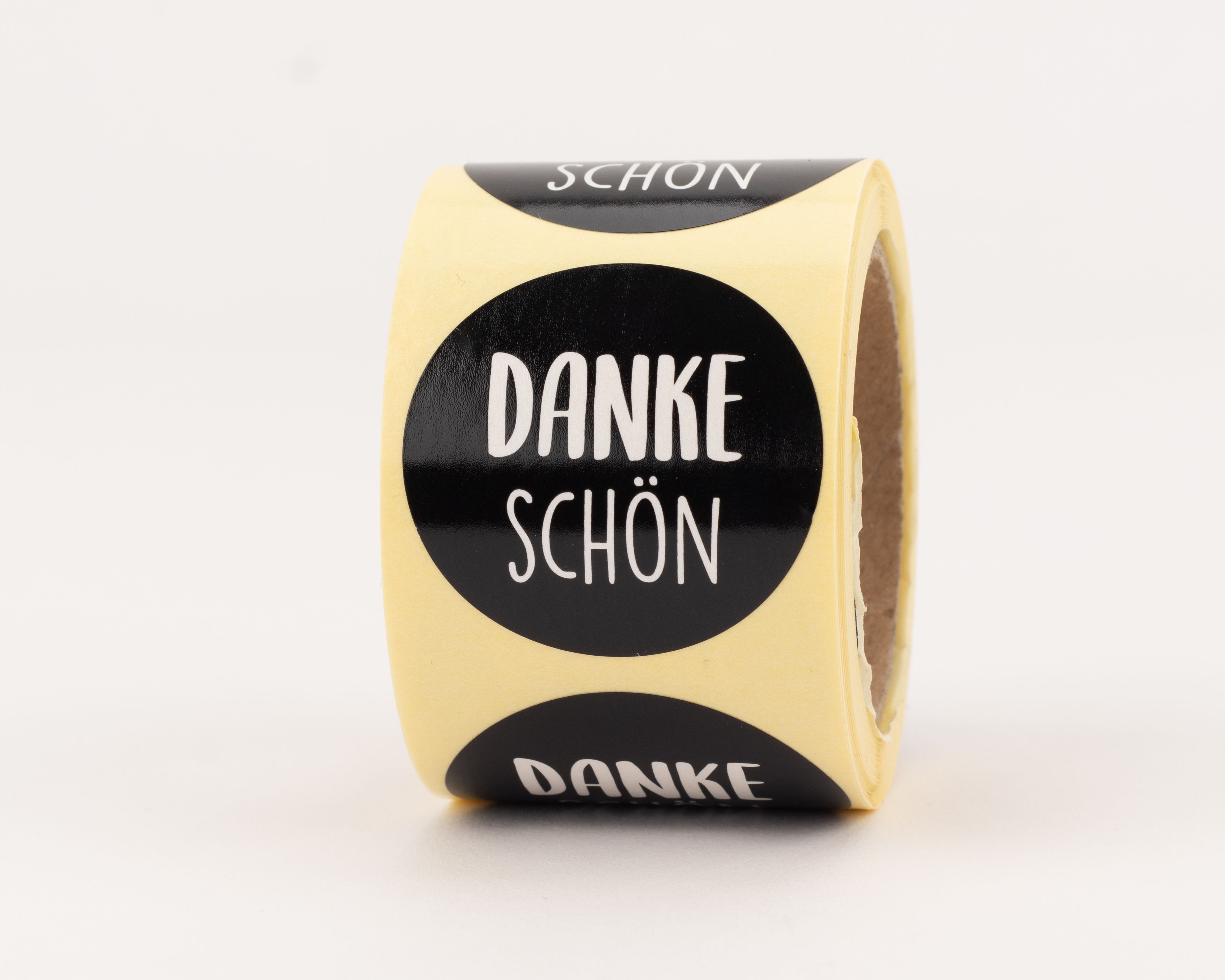 Aufkleber mit einheitlichem rundem Design, schwarzem Hintergrund und weißem Schriftzug DANKE SCHÖN