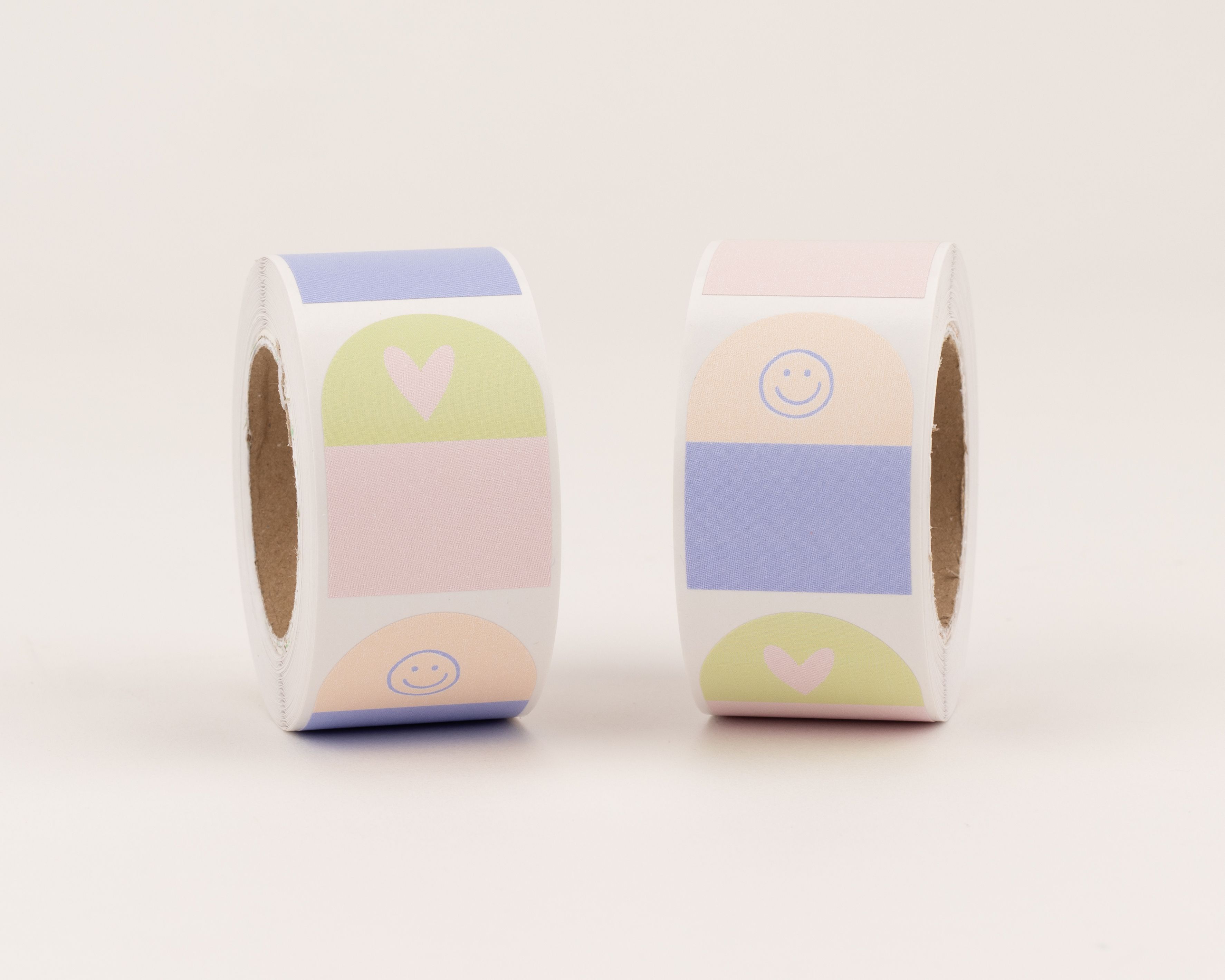 Aufkleber mit zwei Designs, Herz- und Smiley-Motiven in Pastellfarben. Sie zeigen abwechselnd Muster in Rosa, Grün, Orange und Hellblau