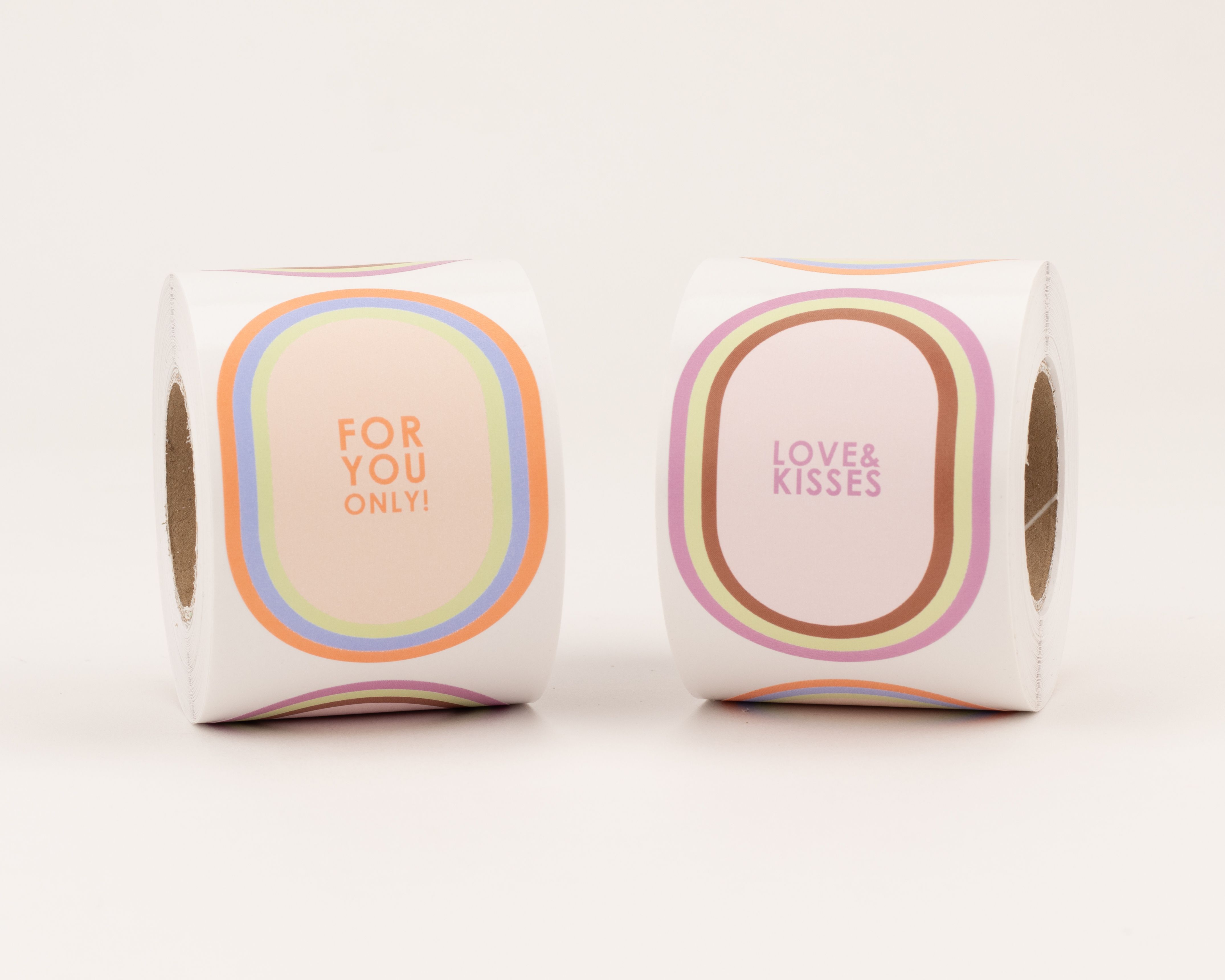 Aufkleber mit zwei verschiedenen ovalen Designs: Eines mit 'For You Only' in orangen Tönen, das andere mit 'Love & Kisses' in violetten Pastellfarben