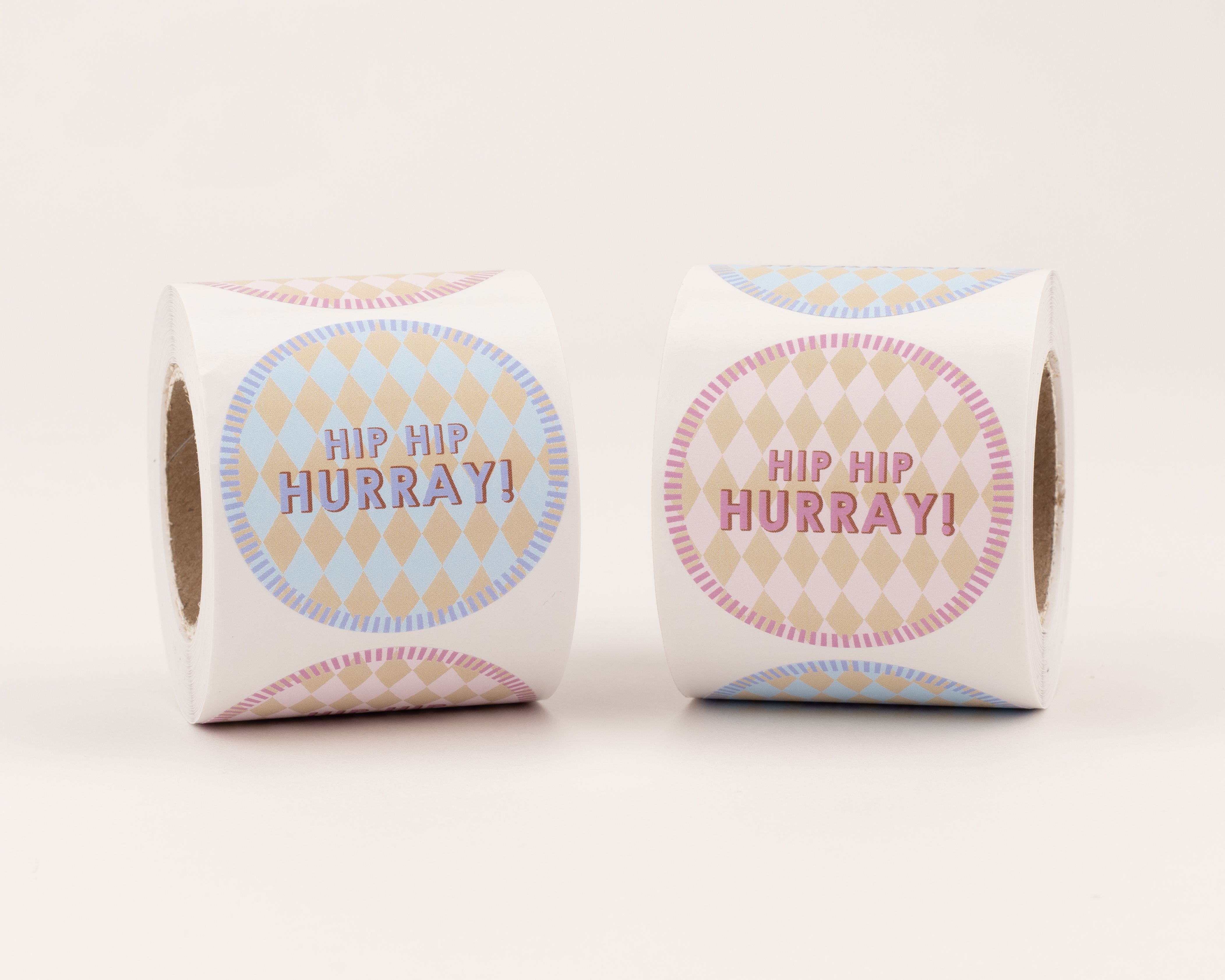 Aufkleber mit zwei runden Motiven. Hellblaue und rosafarbene Rautenmuster sind mit 'Hip Hip Hurray' zu sehen