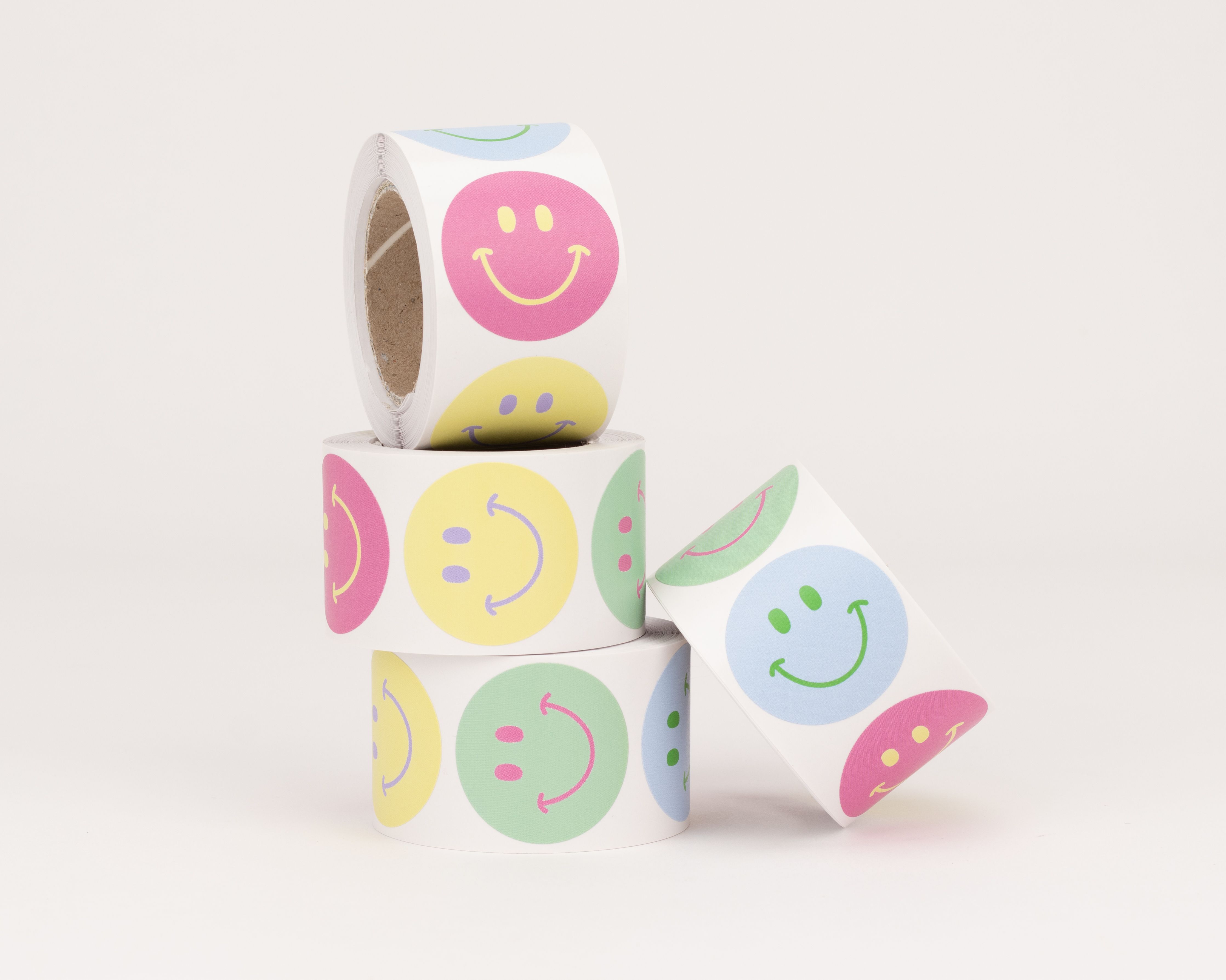 Aufkleber mit runden Smiley Motiven in den Pastellfarben Blau Gruen Gelb und Pink zeigen verschiedene laechelnde Gesichter