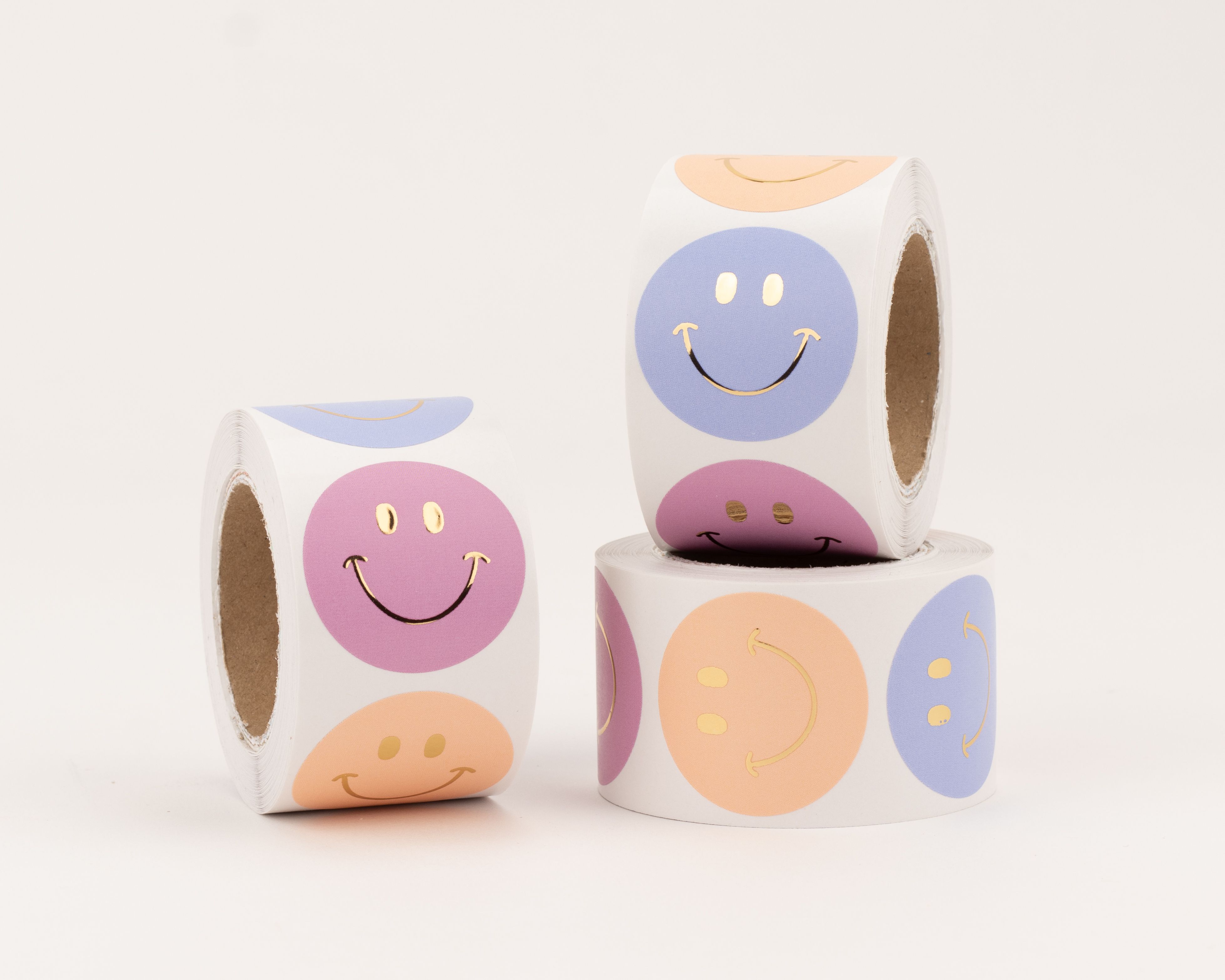 Sticker mit drei verschiedenen Smiley-Designs in den Farben Pink, Blau und Orange, alle Gesichter zeigen einen glänzenden Gold-Effekt