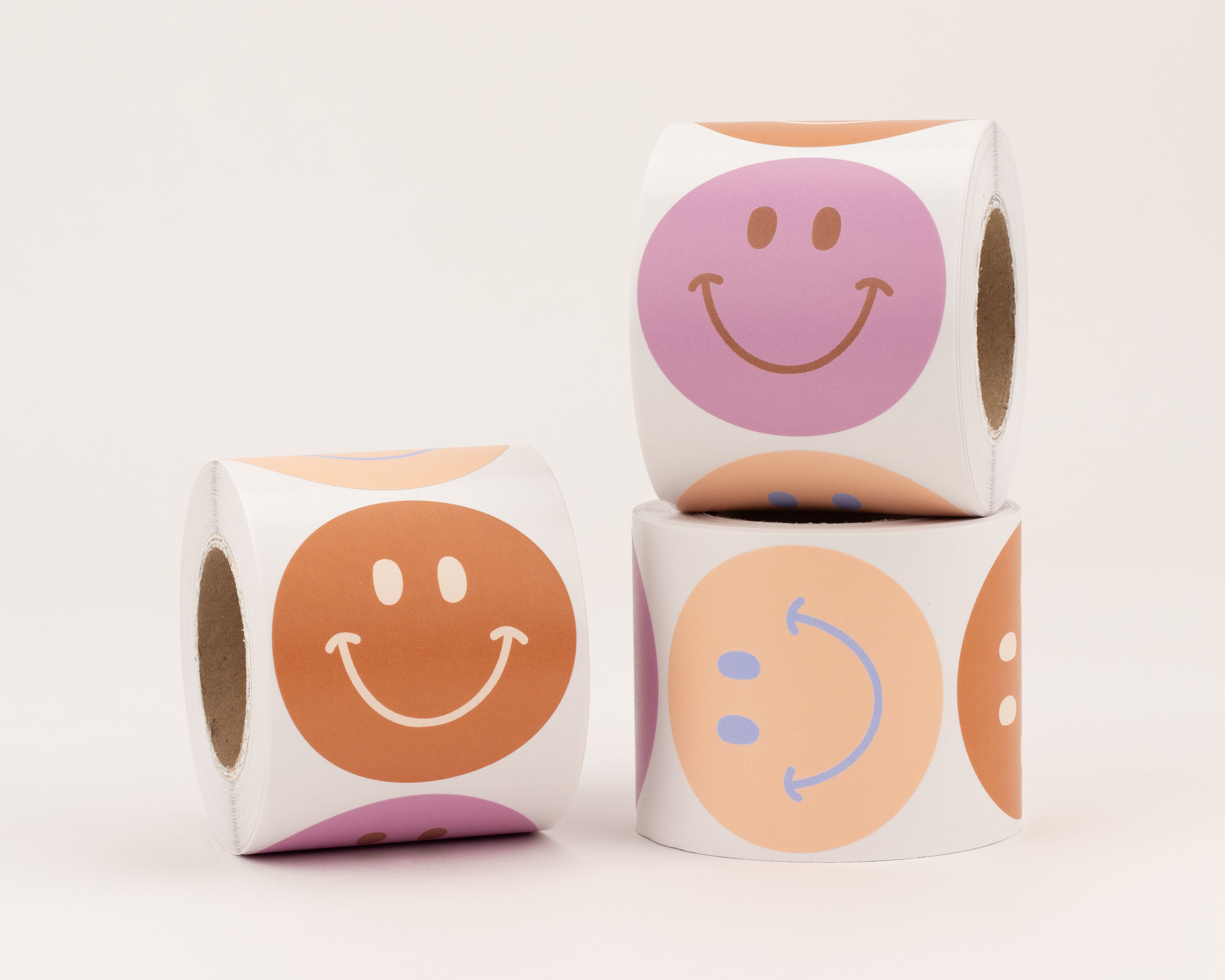 Aufkleber mit drei verschiedenen Smiley-Motiven in den Farben Rost, Pink und Orange, jedes mit einem einzigartigen Gesichtsausdruck