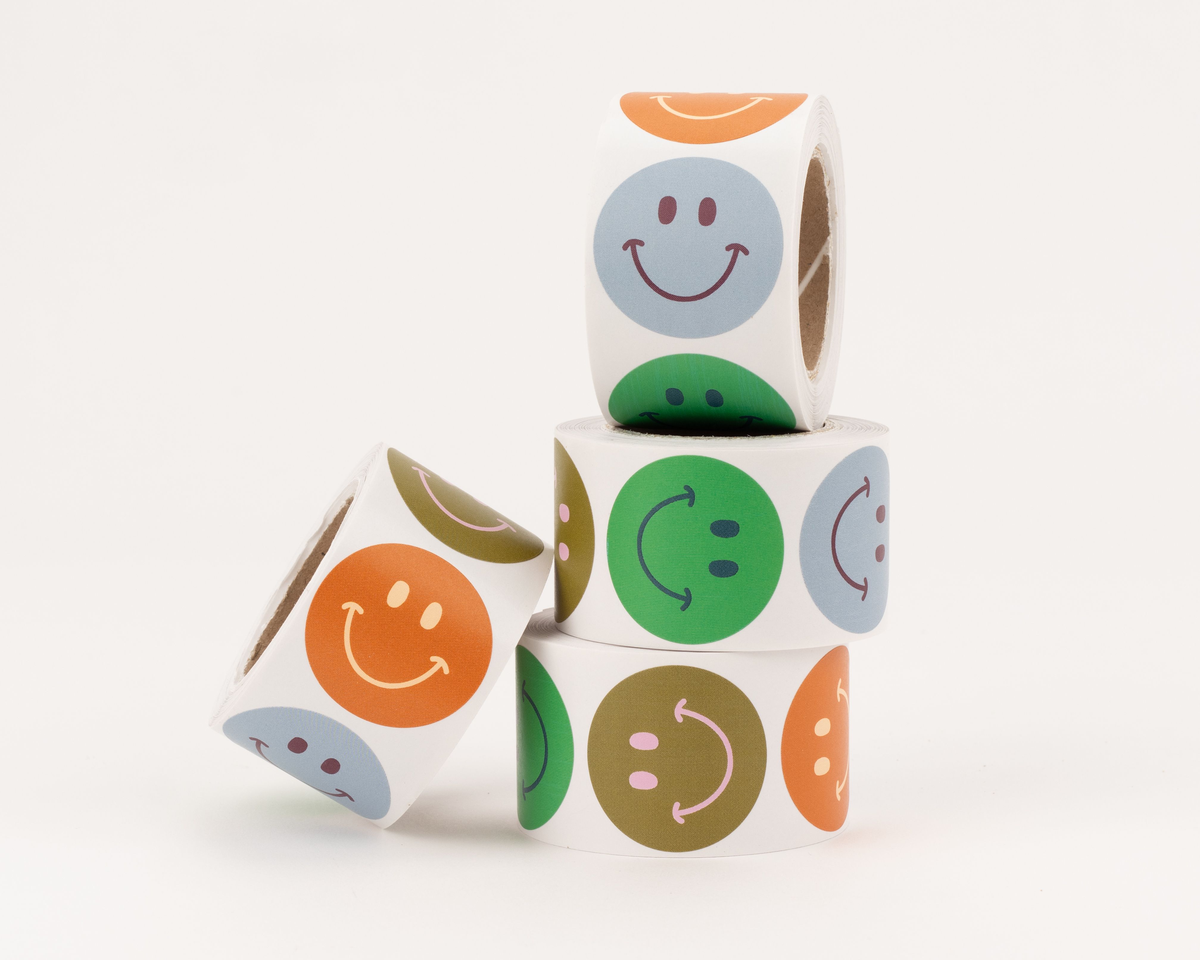 Aufkleber mit verschiedenen runden Smiley-Designs in den Farben Rost, Blau, Grün und Olivgrün, jeweils mit kontrastierender Mimik
