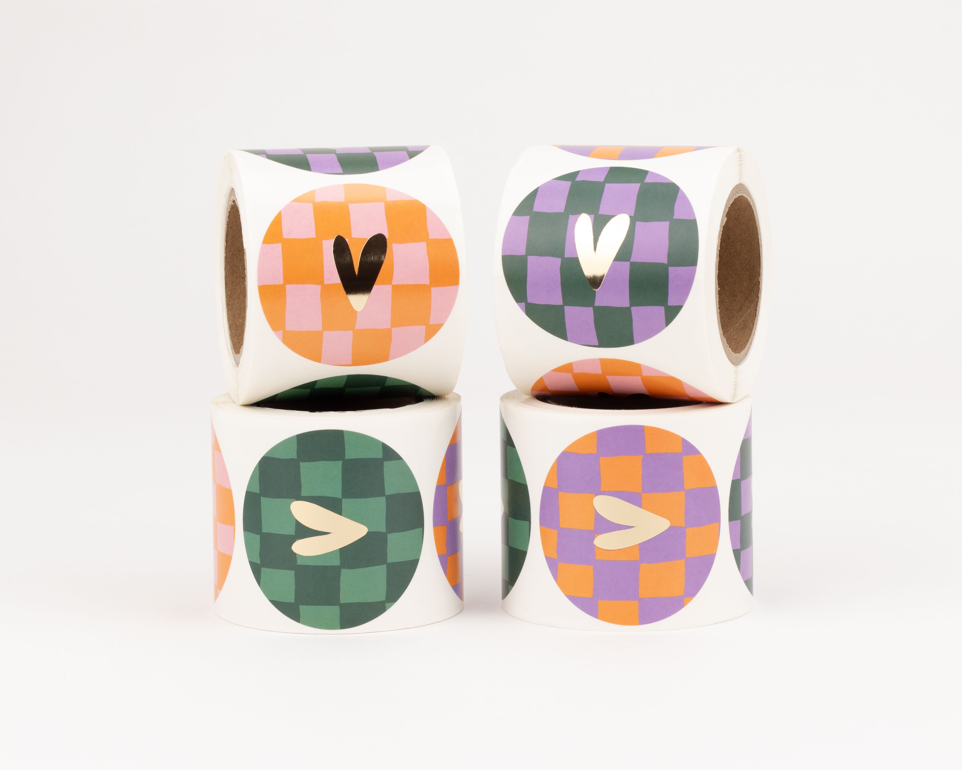 Aufkleber in einem 4er-Set mit verschiedenen Motiven und Farben, darunter Herz- und Schachbrettmuster in Orange, Pink, Grün und Lila