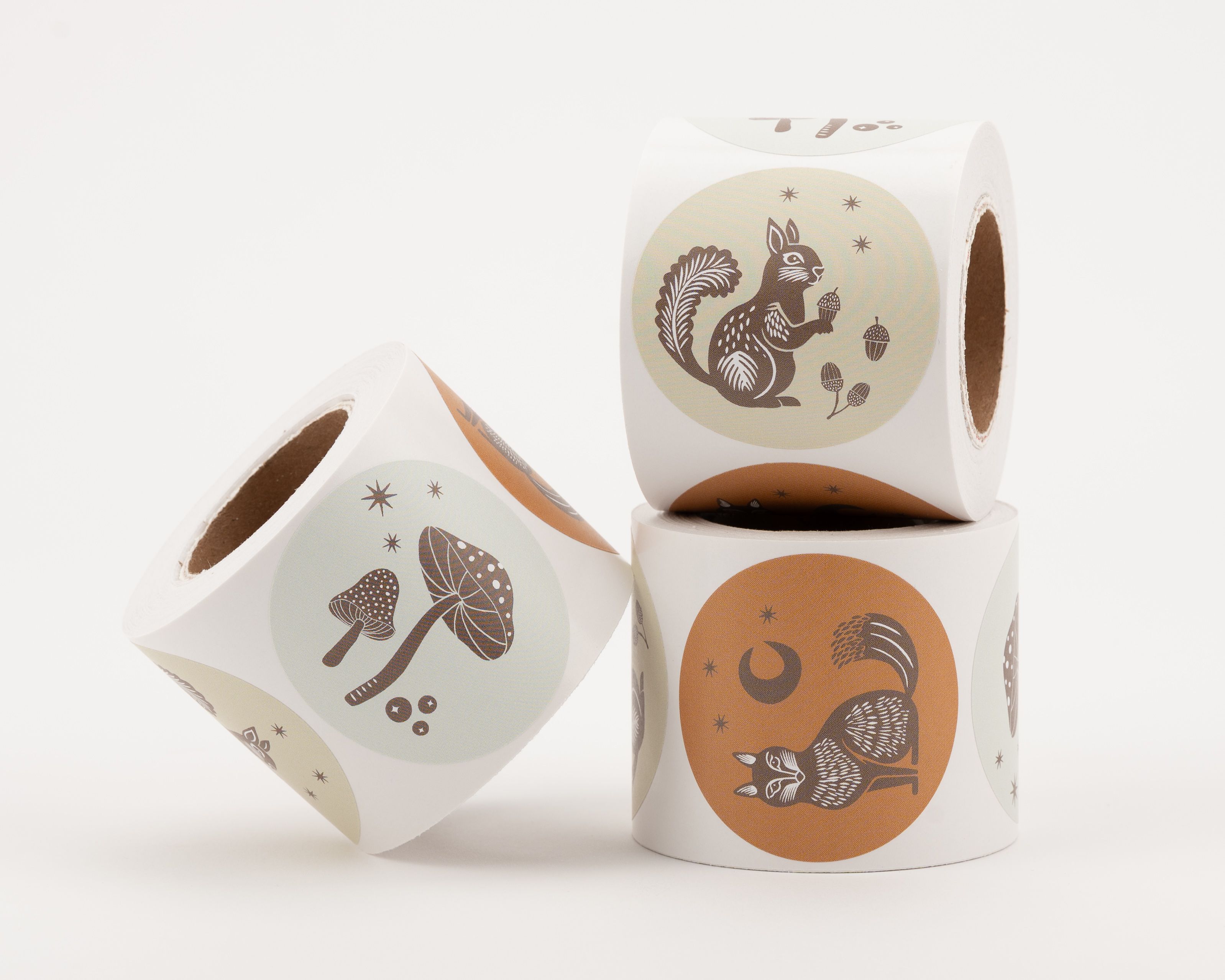 Runde Aufkleber mit herbstlichen Motiven wie Eichhörnchen, Pilzen und einem Fuchs, in den Farben Zimt, Elfenbein und Hellgrau