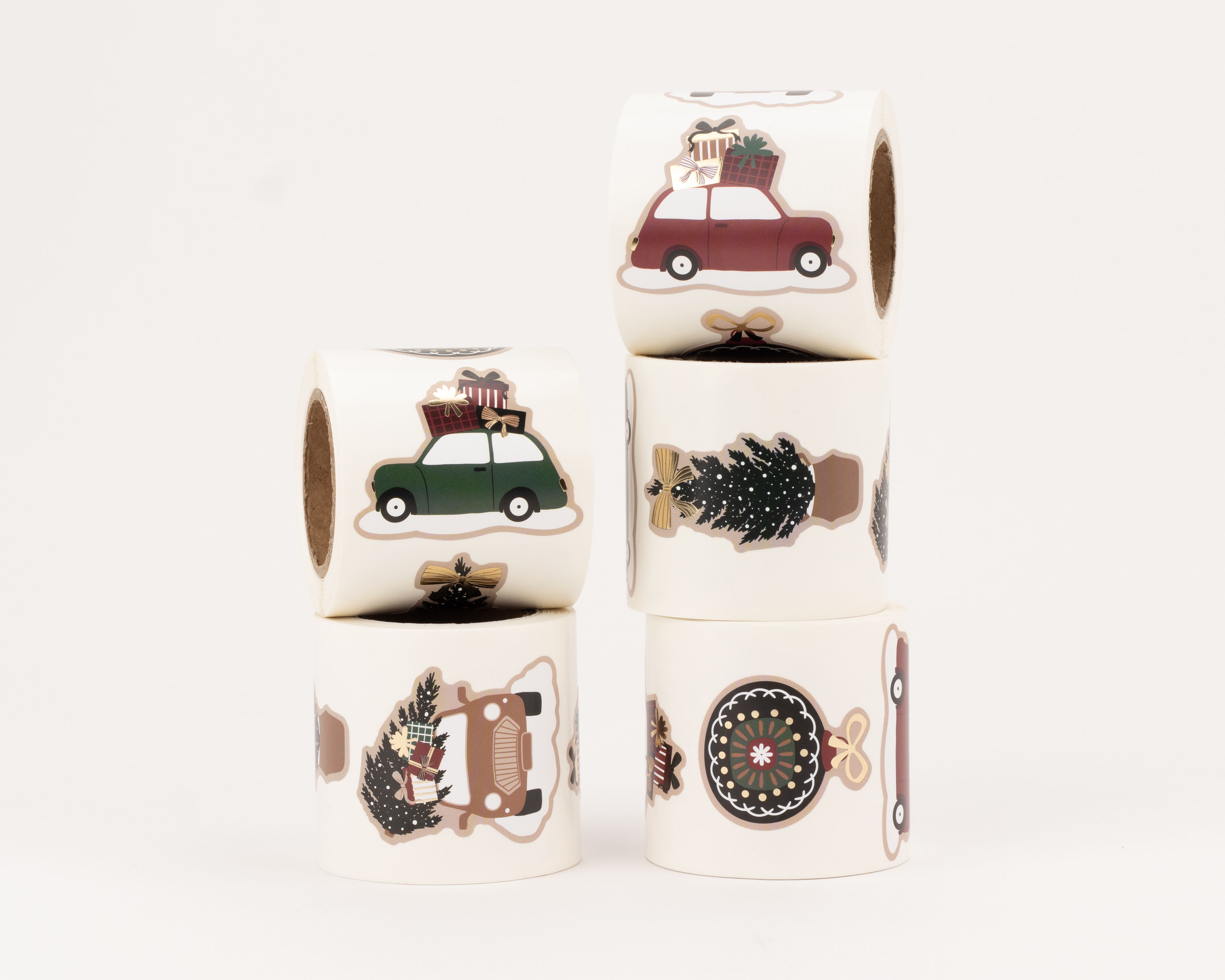 Aufkleber mit fünf verschiedenen weihnachtlichen Motiven, darunter Autos mit Geschenken, Tannenbäume und eine Christbaumkugel, alle mit Gold-Effekt