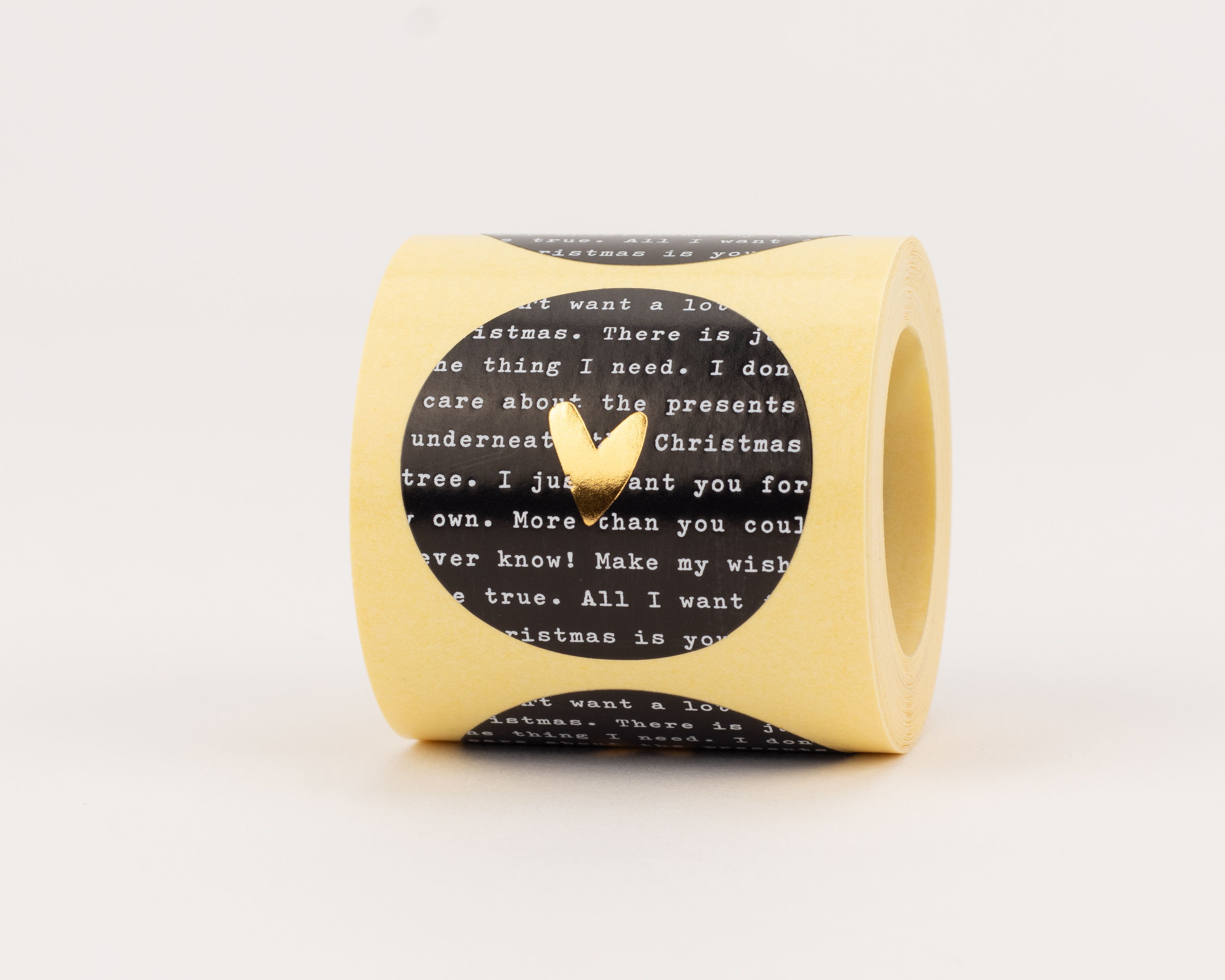 Aufkleber in Schwarz mit weißem 'Christmas Wishes' Text und einem mittig platzierten, glänzenden goldenen Herzmotiv