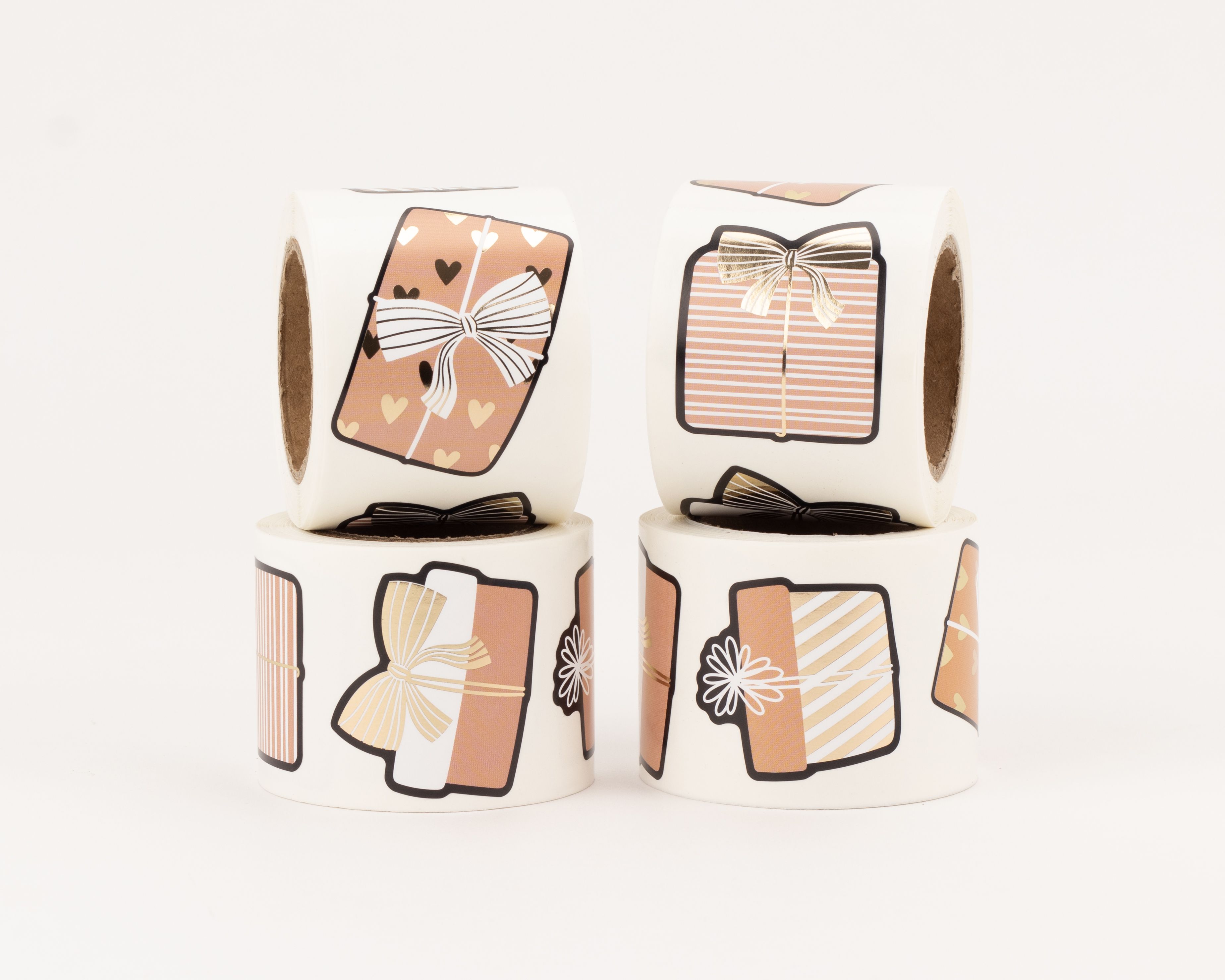 Aufkleber mit vier verschiedenen Geschenk-Designs in den Farben Weiß, Rosabraun und Gold, teilweise mit elegantem Goldeffekt auf den Schleifen und Mustern