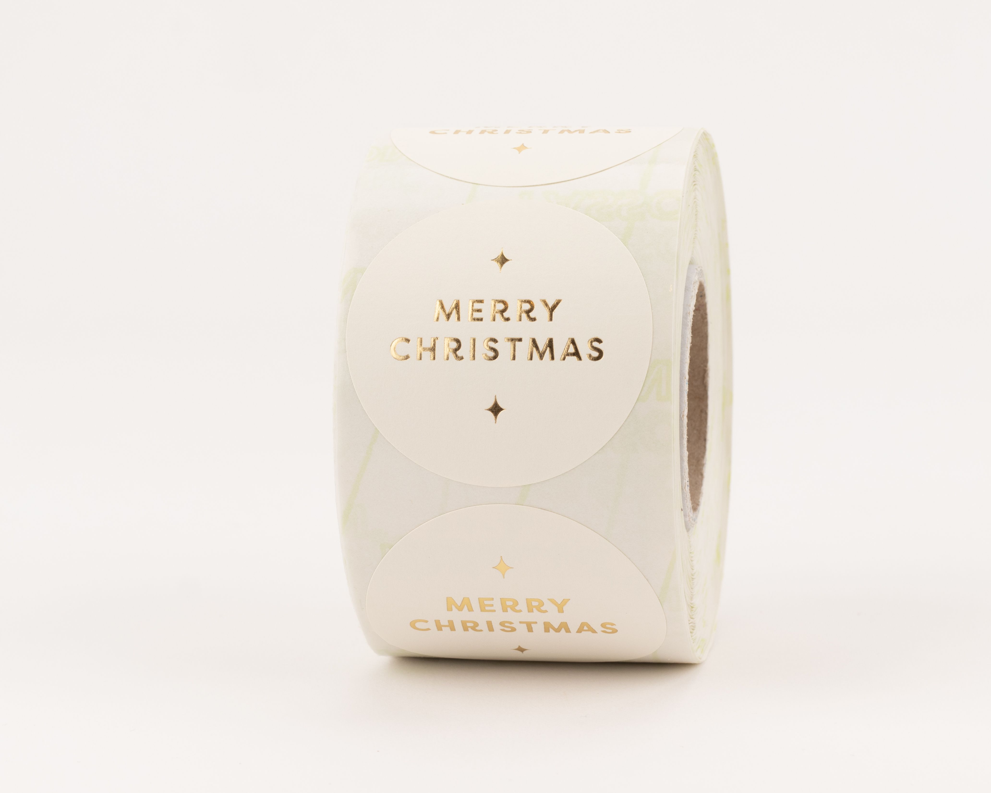 Runde Aufkleber mit cremfarbenem Hintergrund und goldenem "Merry Christmas" Schriftzug sowie funkelnden Sternen