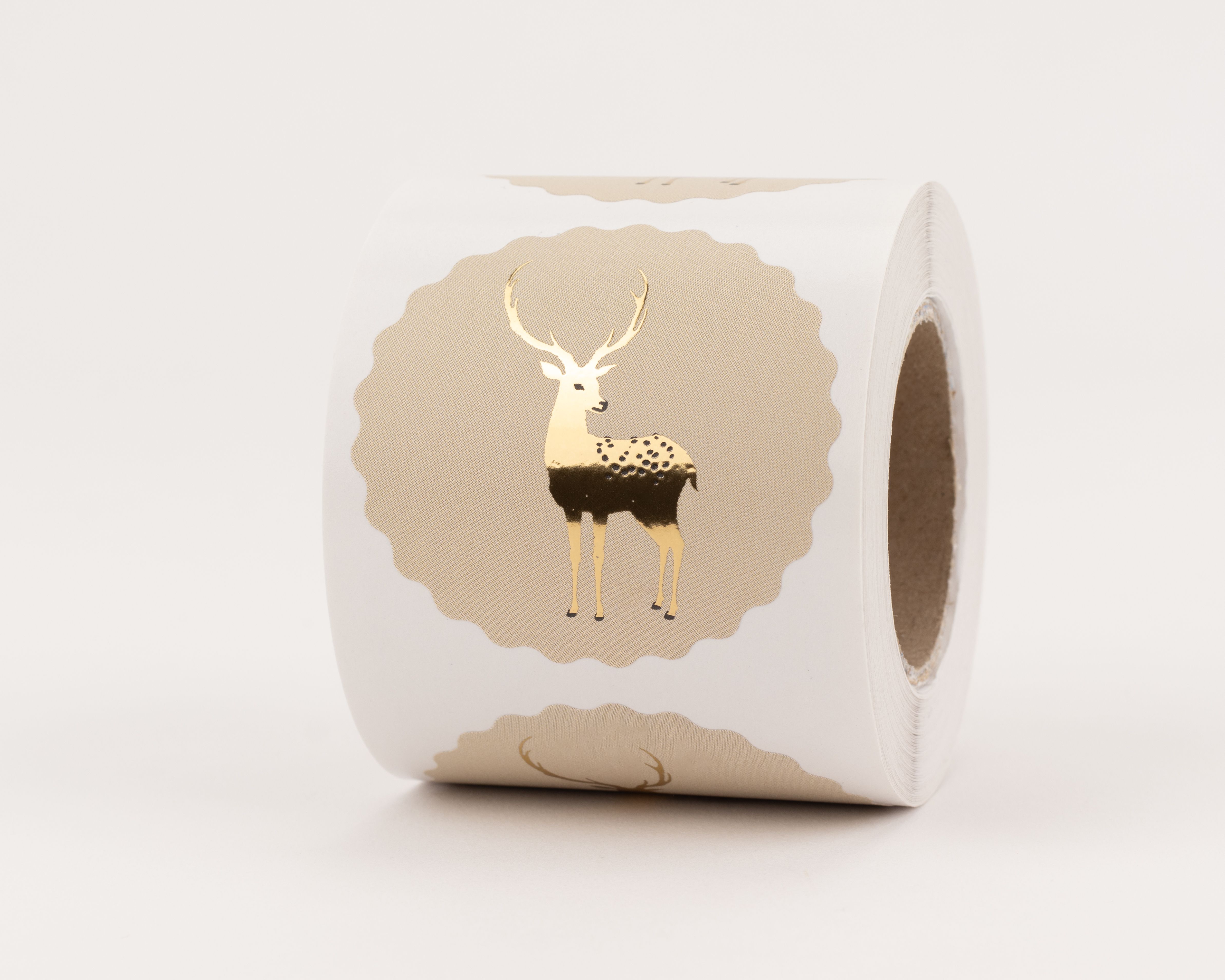 Aufkleber mit goldenem Rentier auf beigem Hintergrund. Die Sticker besitzen einen gewellten Rand und glänzende Gold-Akzente
