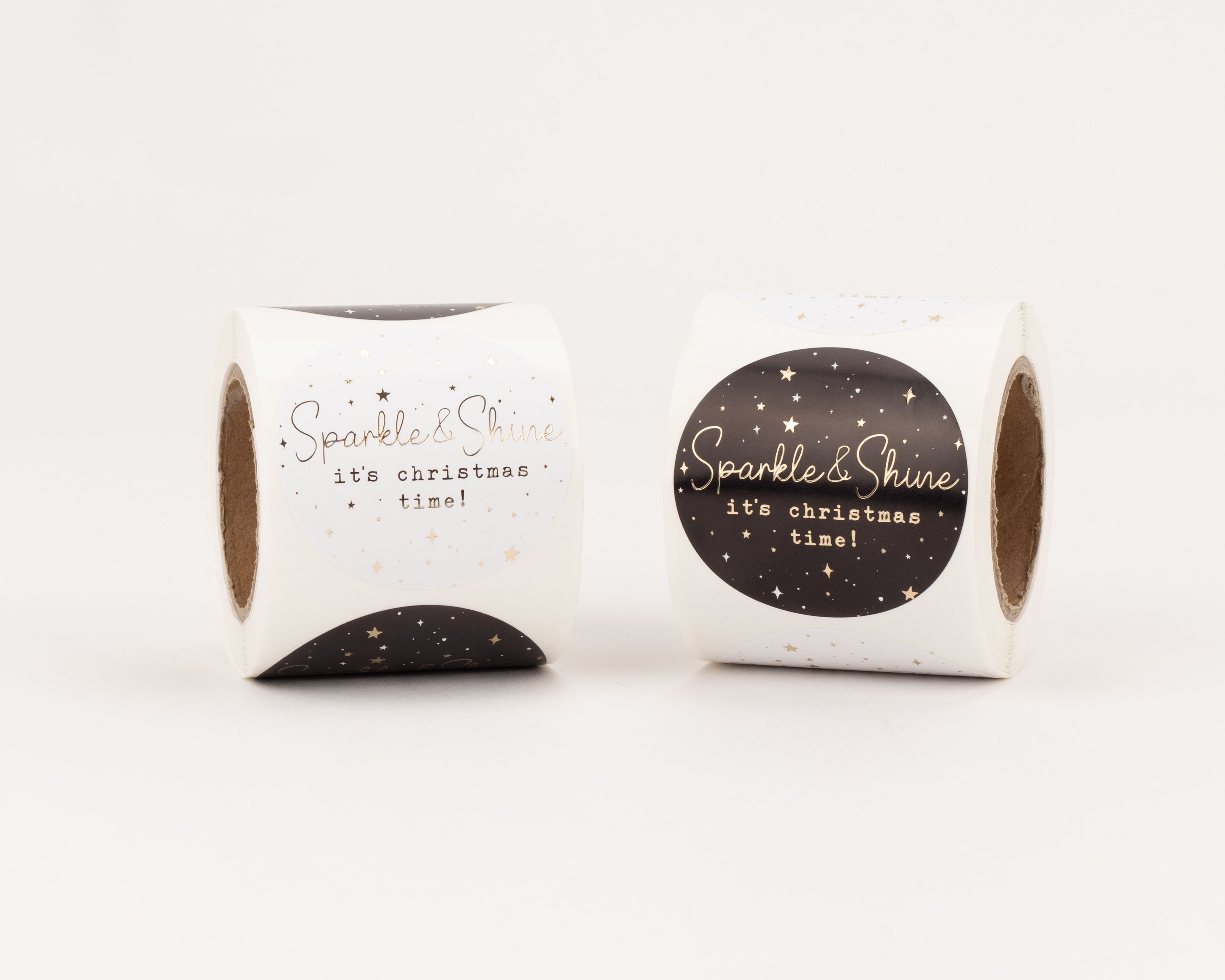 Aufkleber mit zwei verschiedenen Designs, eines weiß und eines schwarz, jeweils mit goldfarbenem Sparkle & Shine Schriftzug und Sternen