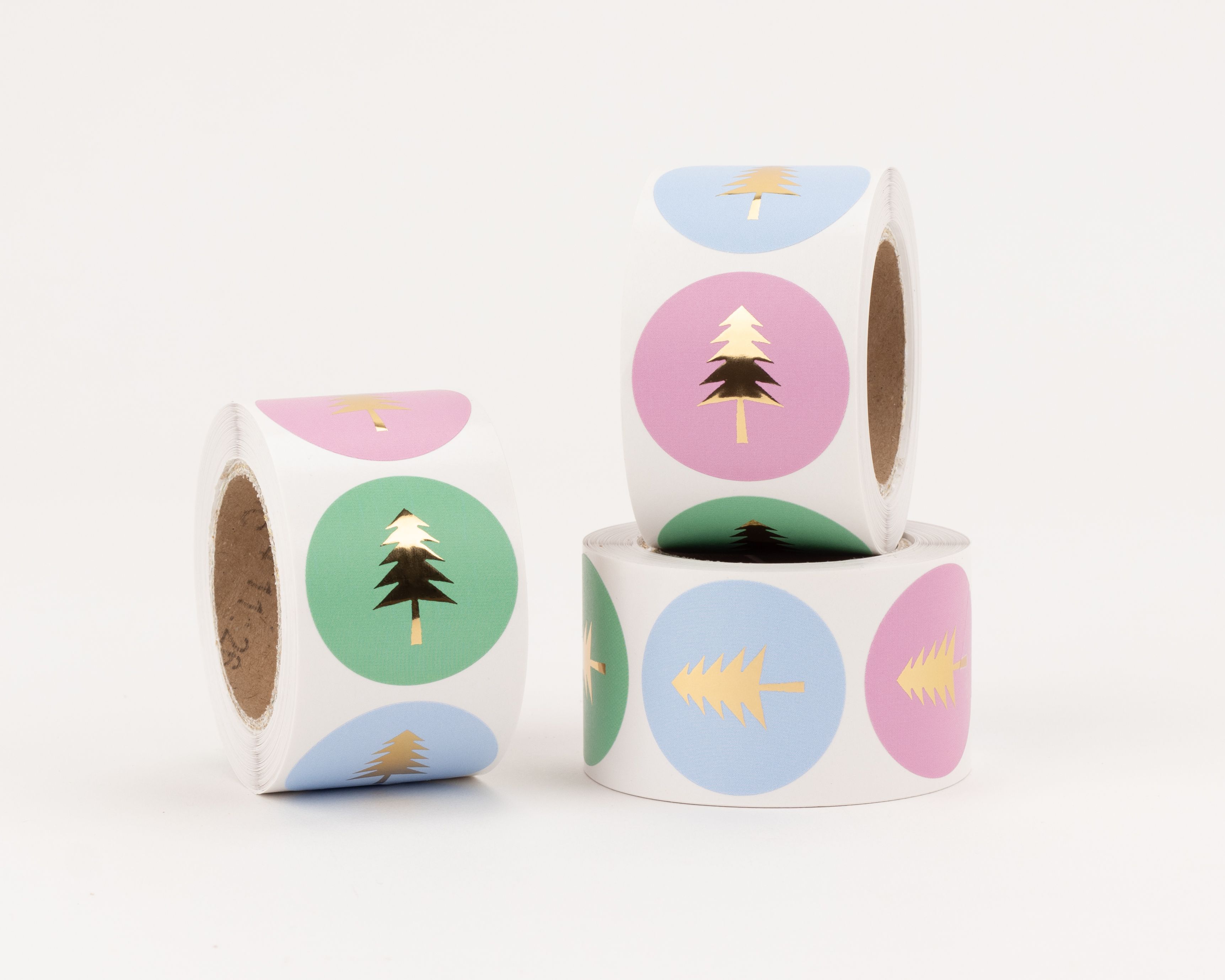Aufkleber mit goldener Tannenbaum-Applikation auf runden Hintergründen in den Farben Grün, Rosa und Blau, verschiedene Designs