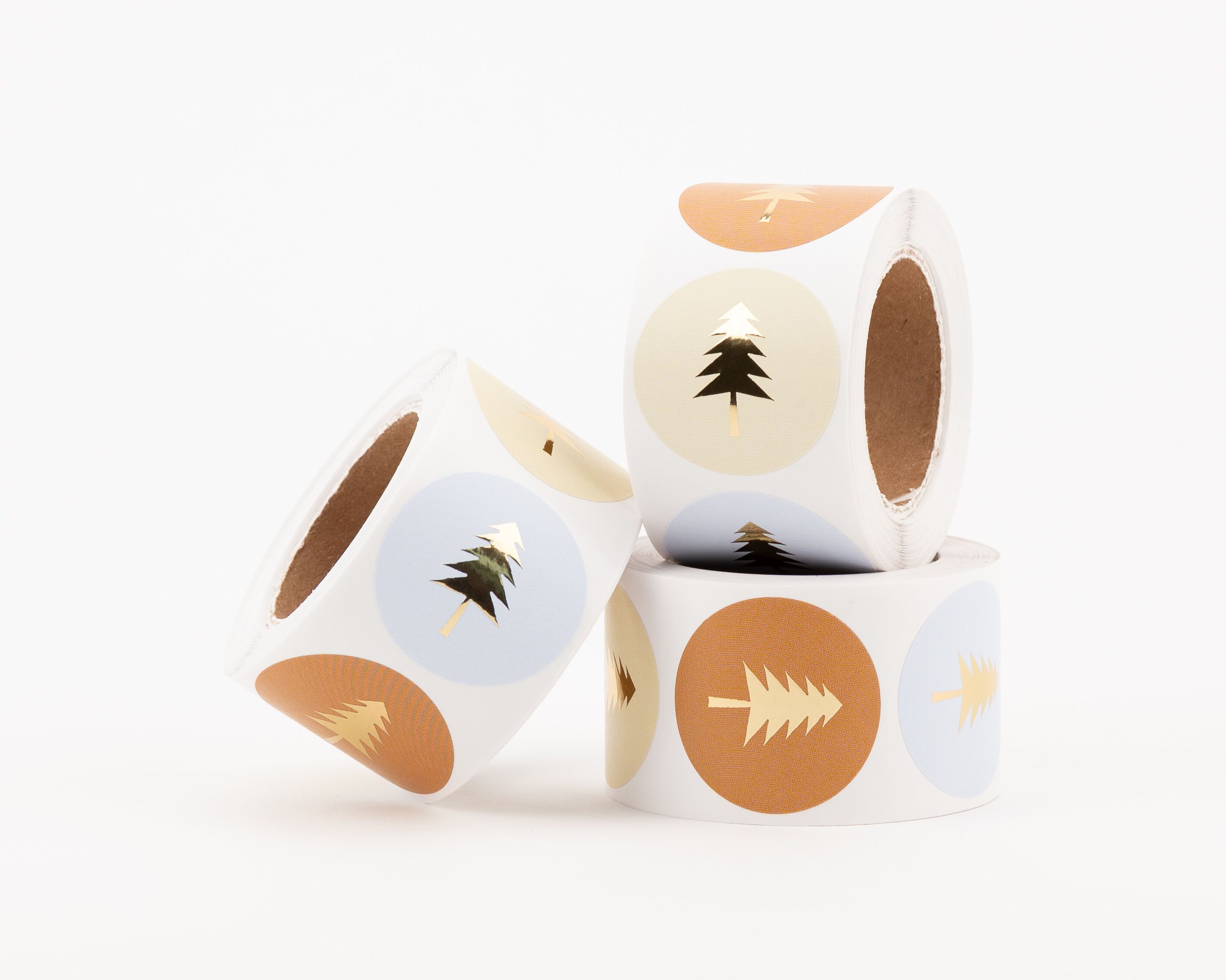 Runde Aufkleber mit verschiedenen Tannen-Designs in Hellblau, Elfenbein und Zimt mit goldenen Tannenbäumen und Goldeffekt