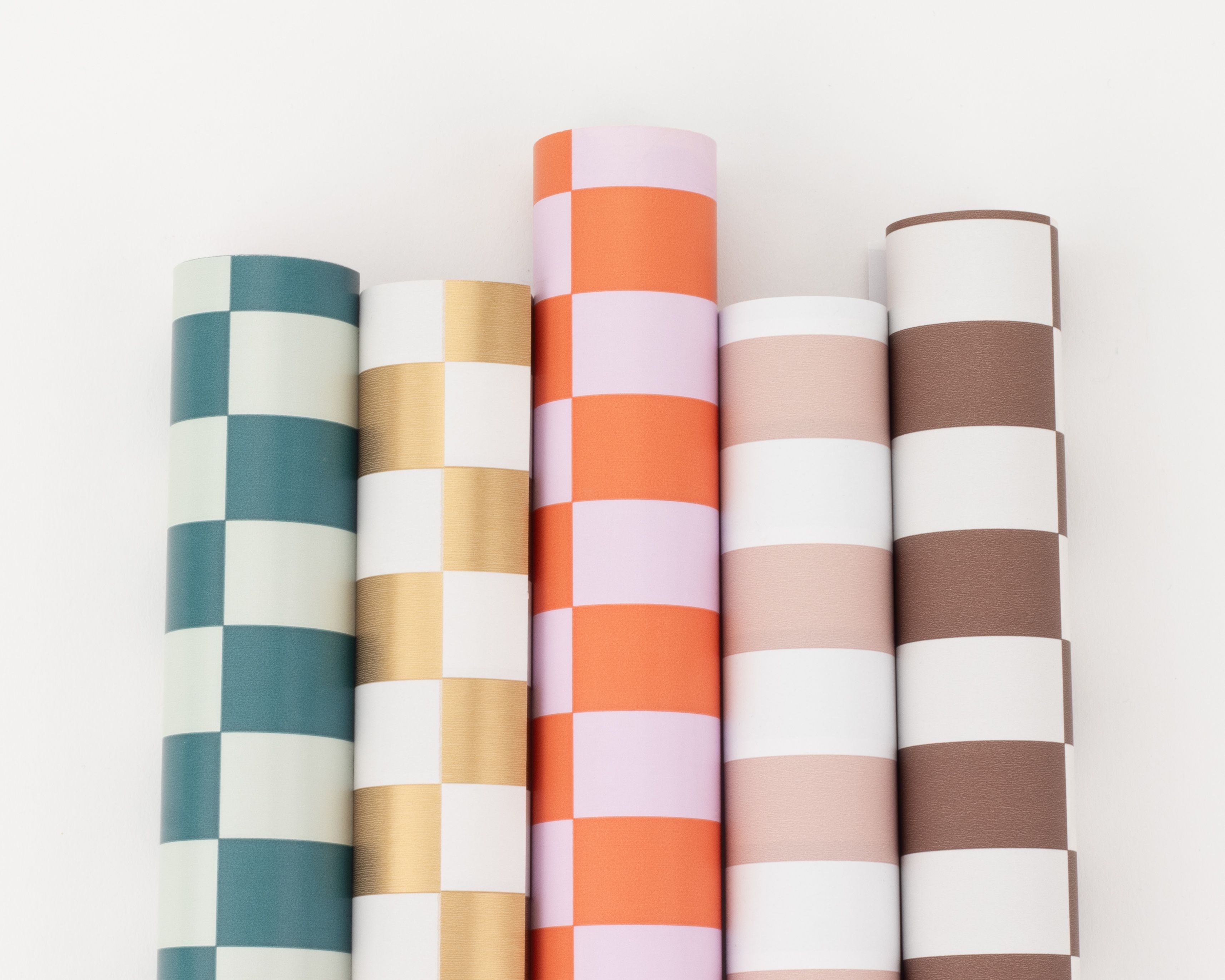 Geschenkpapier-Set mit fünf nebeneinander liegenden Rollen in verschiedenen kräftigen Farben und Blockstreifenmustern
