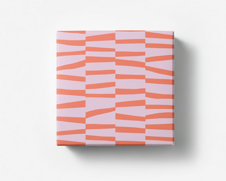 Geschenkpapier mit einem Muster aus dicken Strichen in Neon Korallrot auf fliederfarbenem Hintergrund, als verpacktes Geschenk