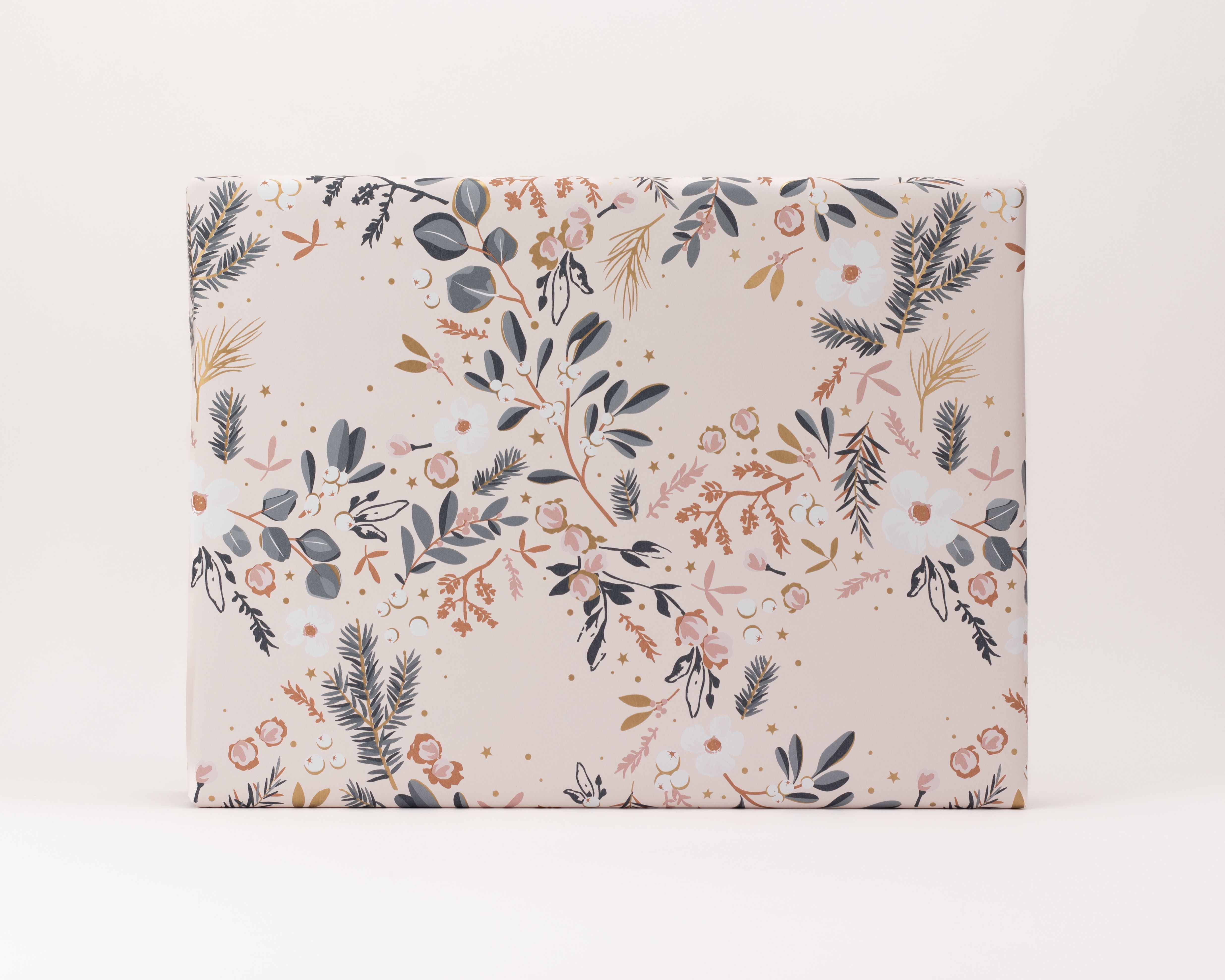 Geschenkpapier-Set mit einem floral gemusterten Geschenk. Das Papier zeigt graue Blätter, weiße Blüten und roségoldene Akzente auf hellrosa Hintergrund