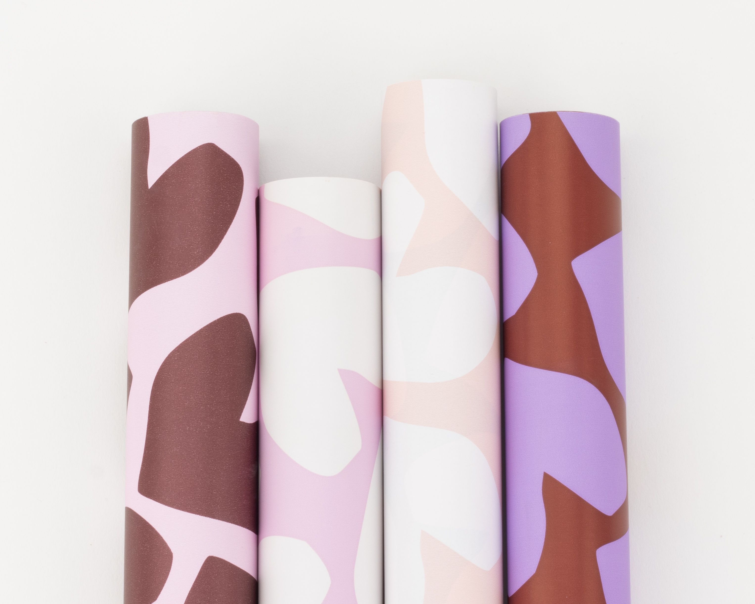 Geschenkpapier-Set mit vier Rollen in Hellrosa, Flieder und Weinrot, alle mit Herz-Mustern