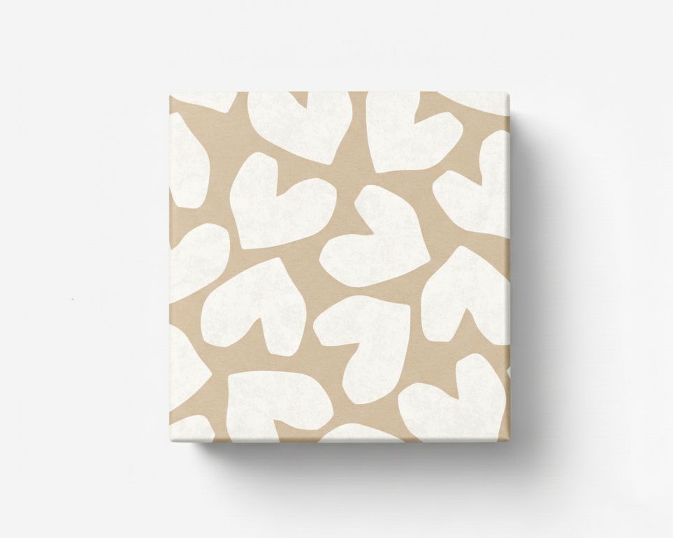 Geschenkpapier mit unregelmäßigen weißen Herzen auf hellbraunem Kraftpapier, dargestellt als verpacktes quadratisches Geschenk
