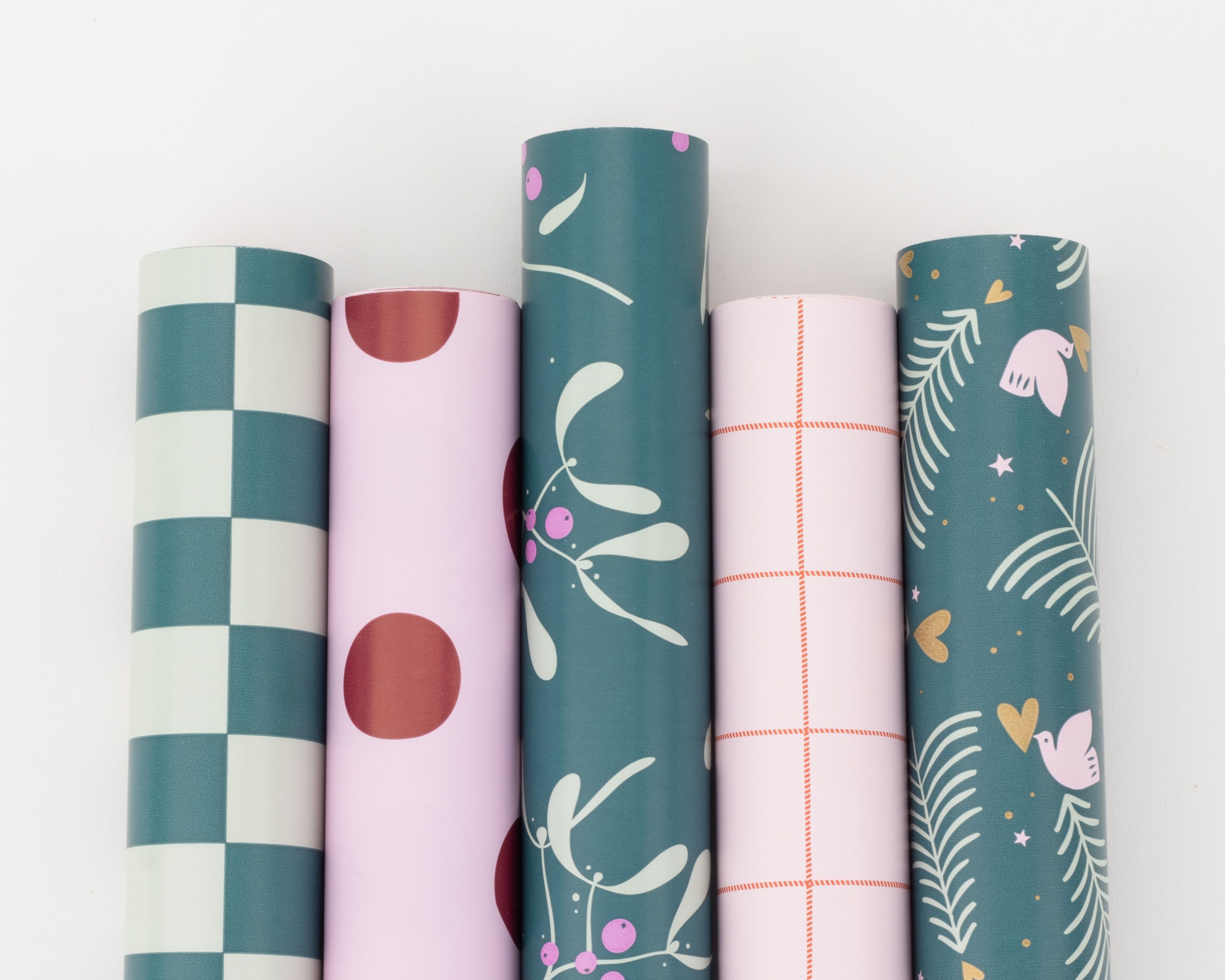 Geschenkpapier-Set mit fünf Rollen in Petrol- und Hellrosa-Tönen, dekoriert mit Blockstreifen, Punkten und weiteren festlichen Mustern