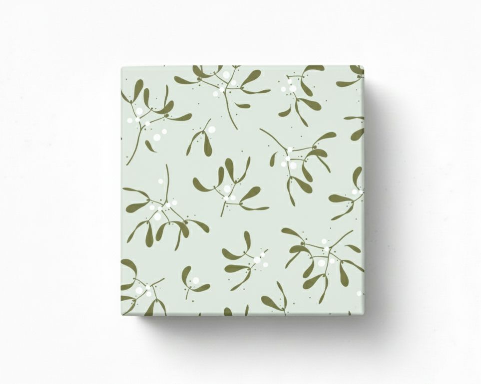 Geschenkpapier mit einem Mistelzweig-Muster in Olivgrün und weißen Beeren auf salbeigrünem Grund, präsentiert als verpacktes Geschenk