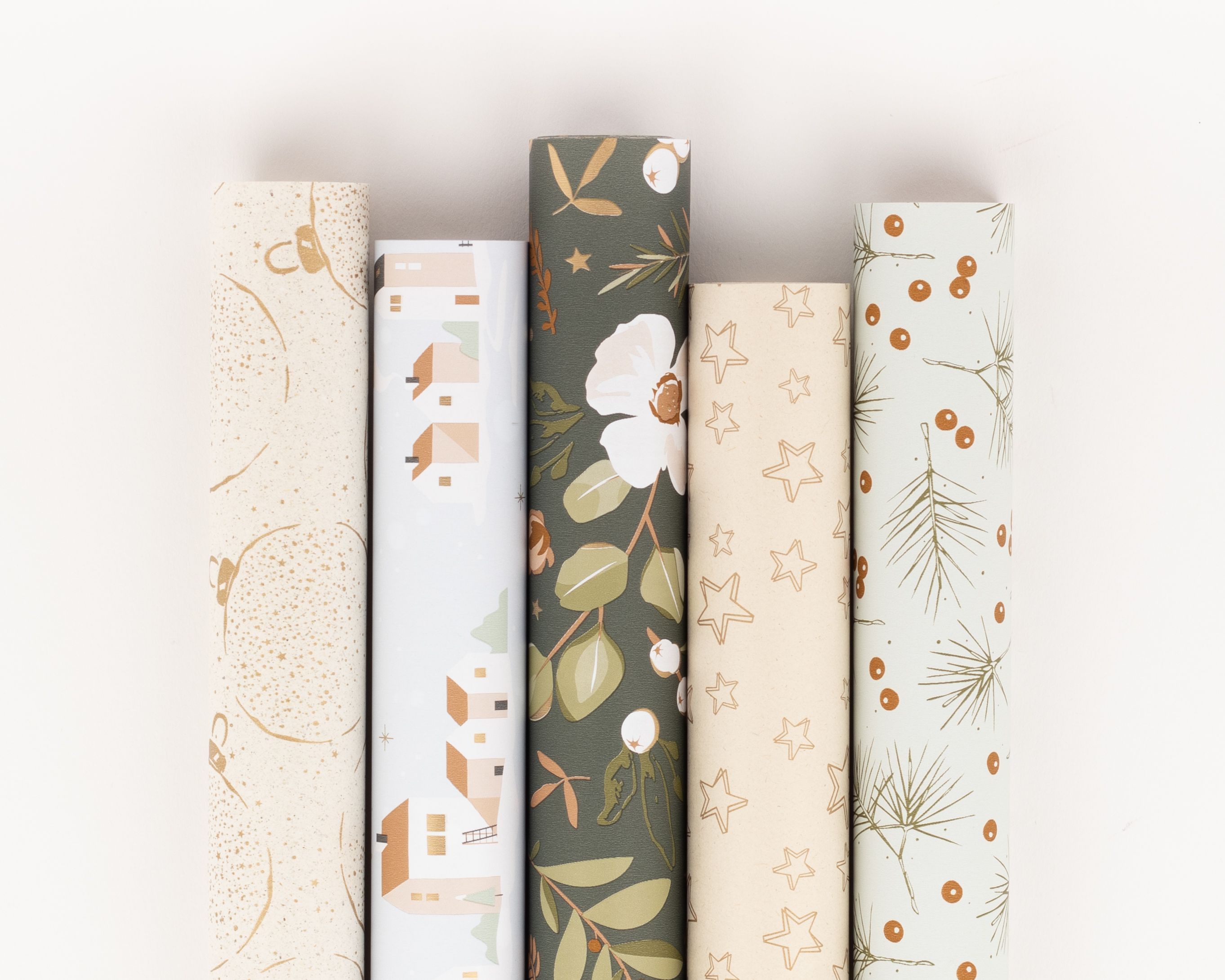 Geschenkpapier-Set mit fünf Rollen, darunter goldene Kugeln, blaues Winterdorf, botanische Muster, goldene Sterne und winterliche Zweige